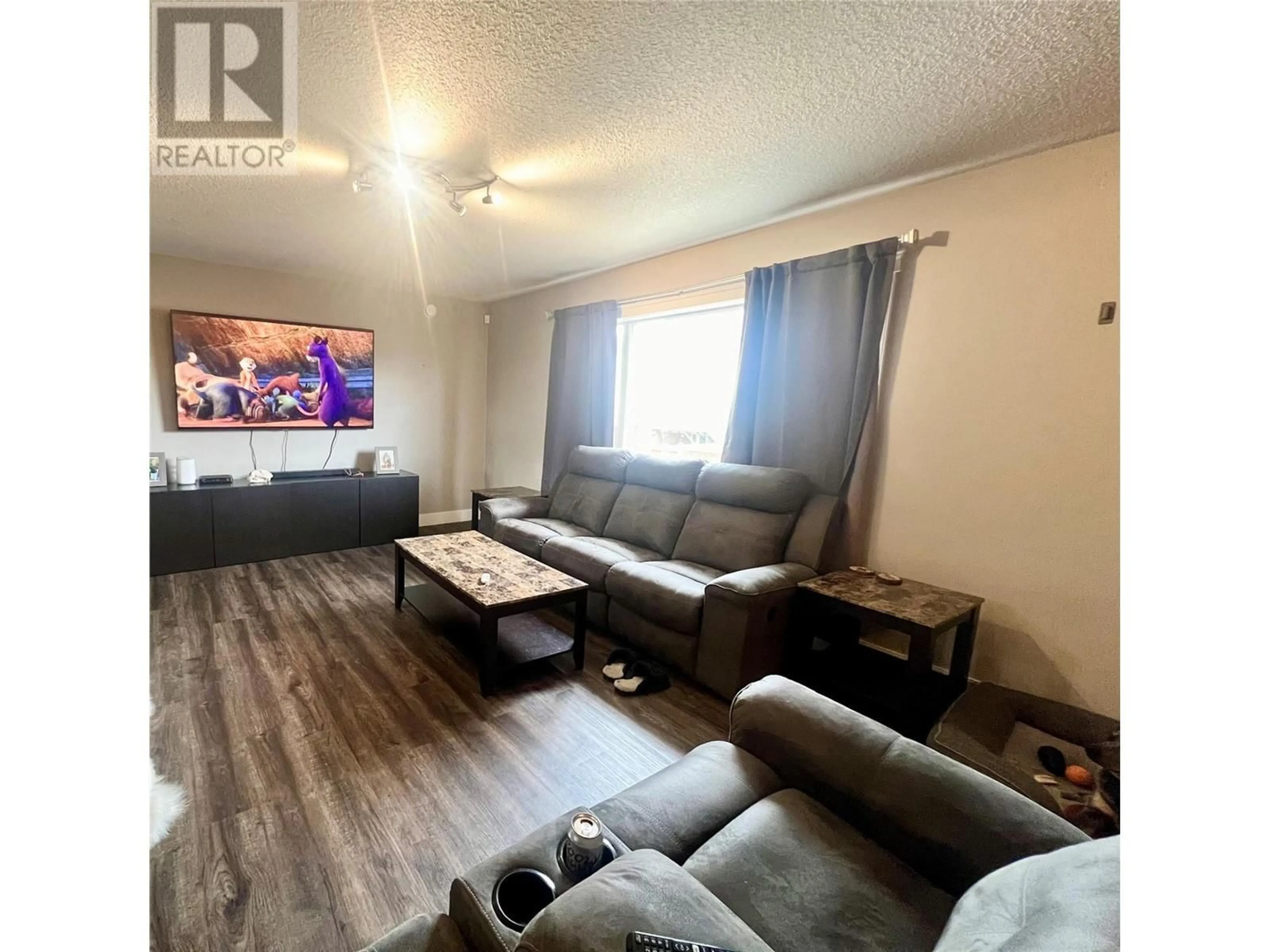 Living room with furniture, wood/laminate floor for 1724 84 AVENUE, Dawson Creek British Columbia V1G0E1