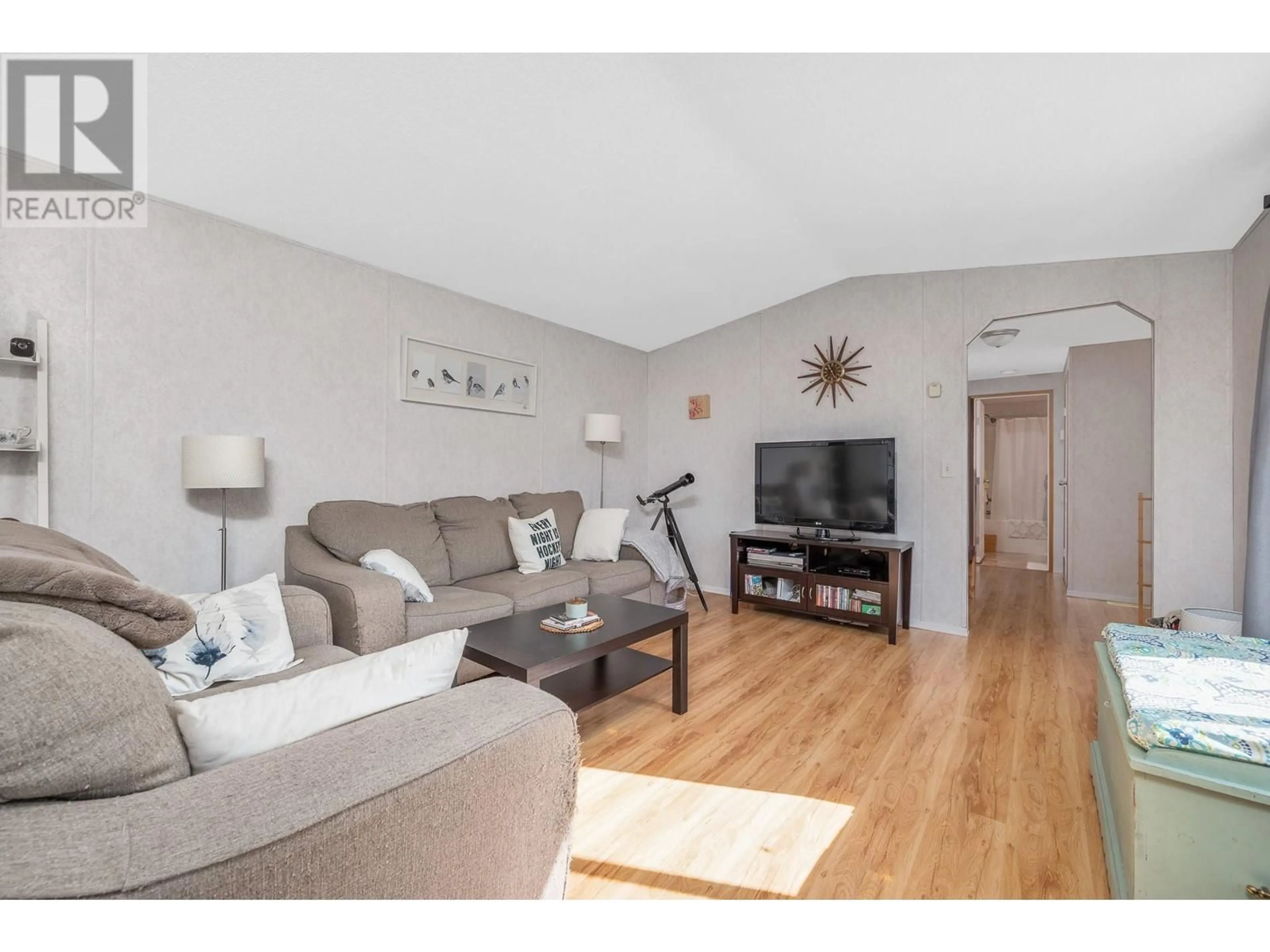 Living room with furniture, wood/laminate floor for 75 - 12560 WESTSIDE ROAD, Vernon British Columbia V1H1S9