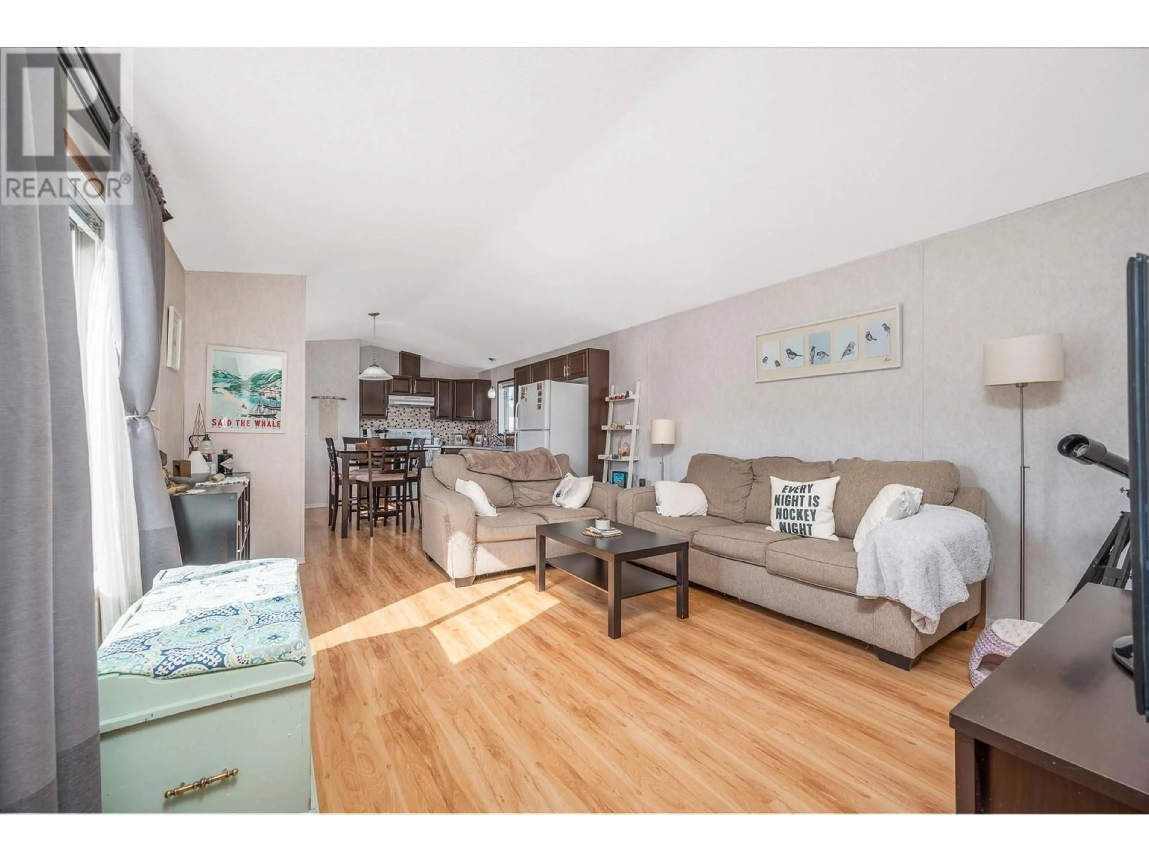 Living room with furniture, wood/laminate floor for 75 - 12560 WESTSIDE ROAD, Vernon British Columbia V1H1S9
