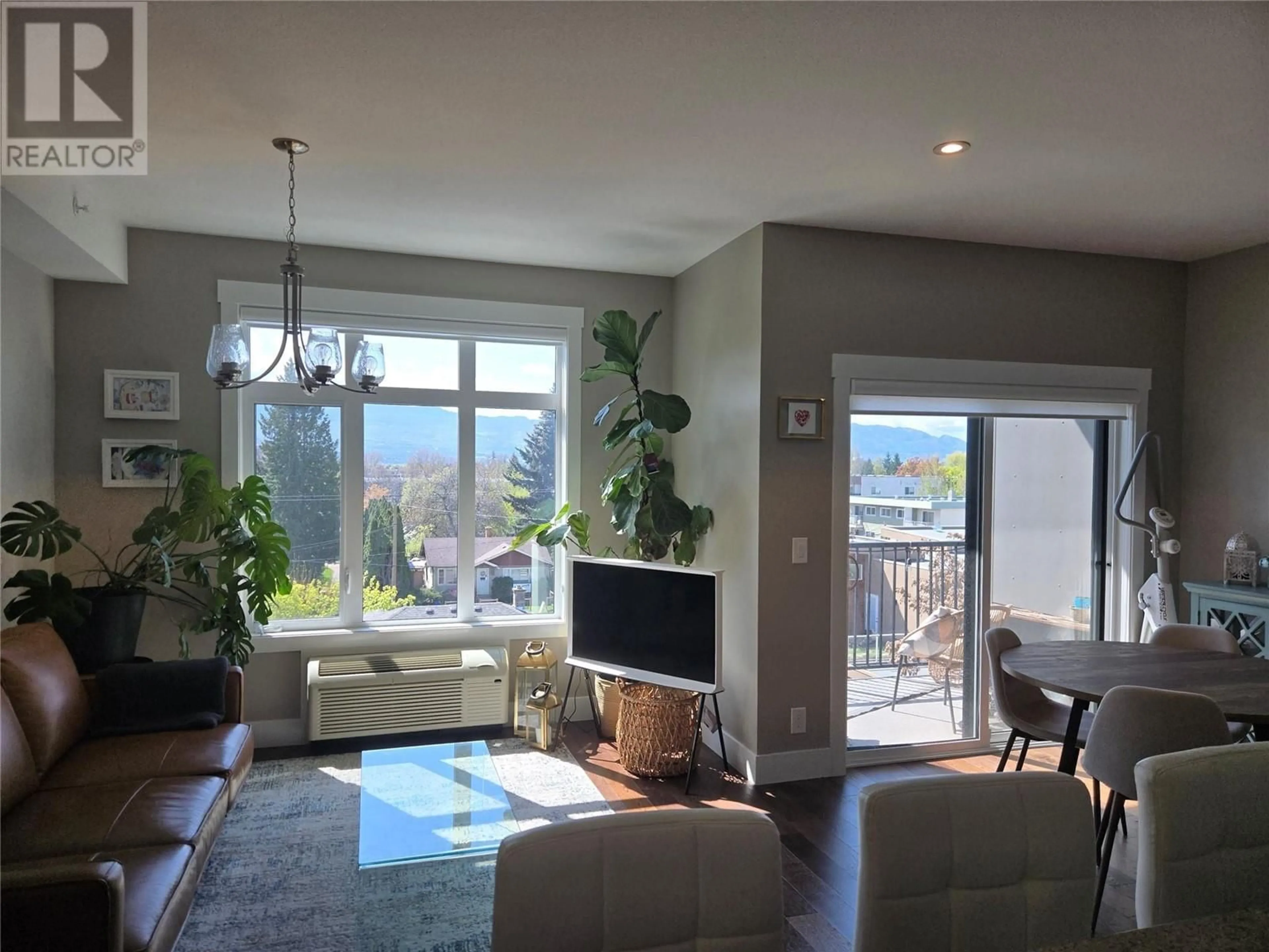 Living room with furniture, wood/laminate floor for 402 - 1165 SUTHERLAND AVENUE, Kelowna British Columbia V1Y5Y2