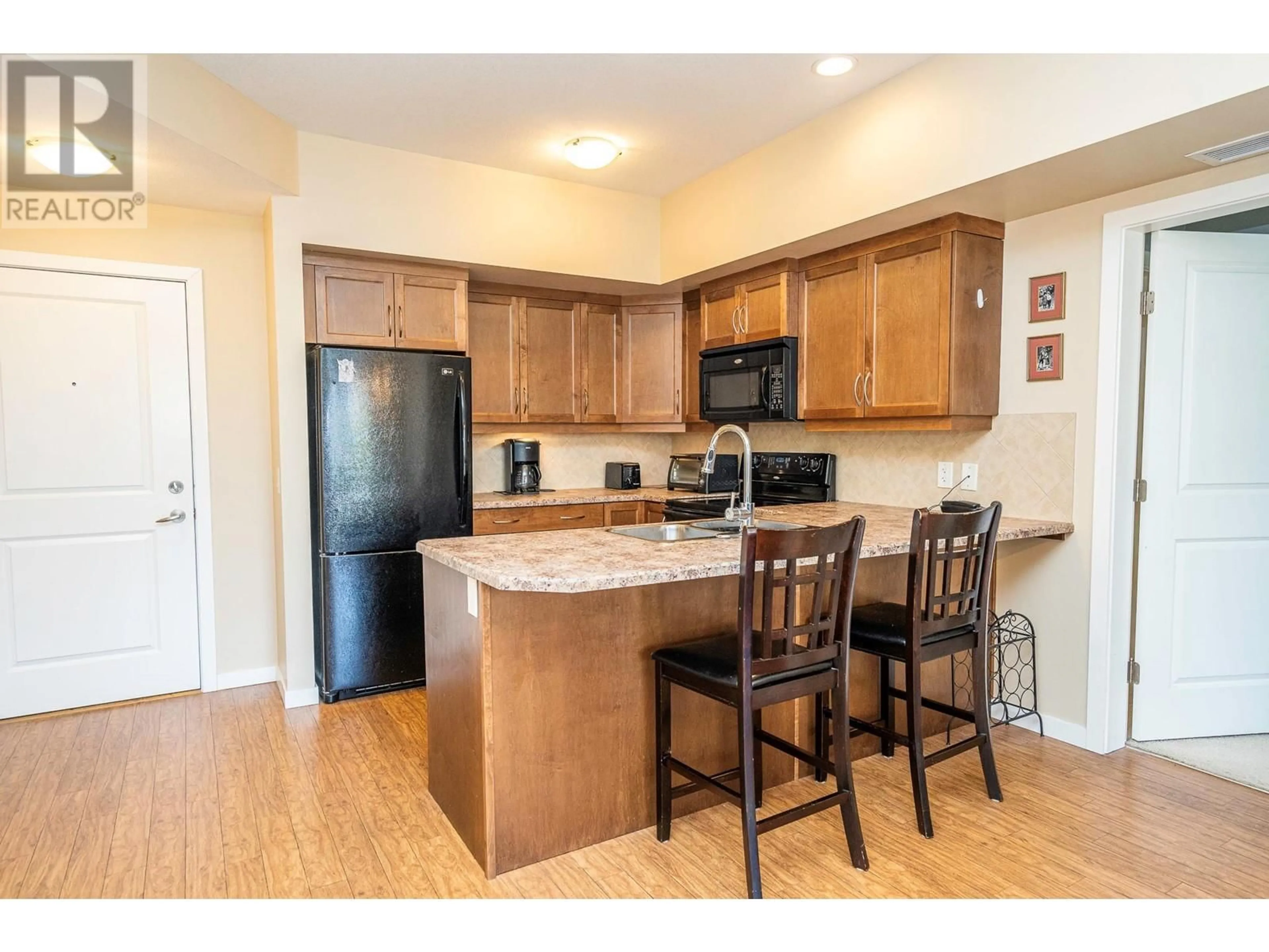 Open concept kitchen, wood/laminate floor for 223 - 850 SAUCIER AVENUE, Kelowna British Columbia V1Y6A3