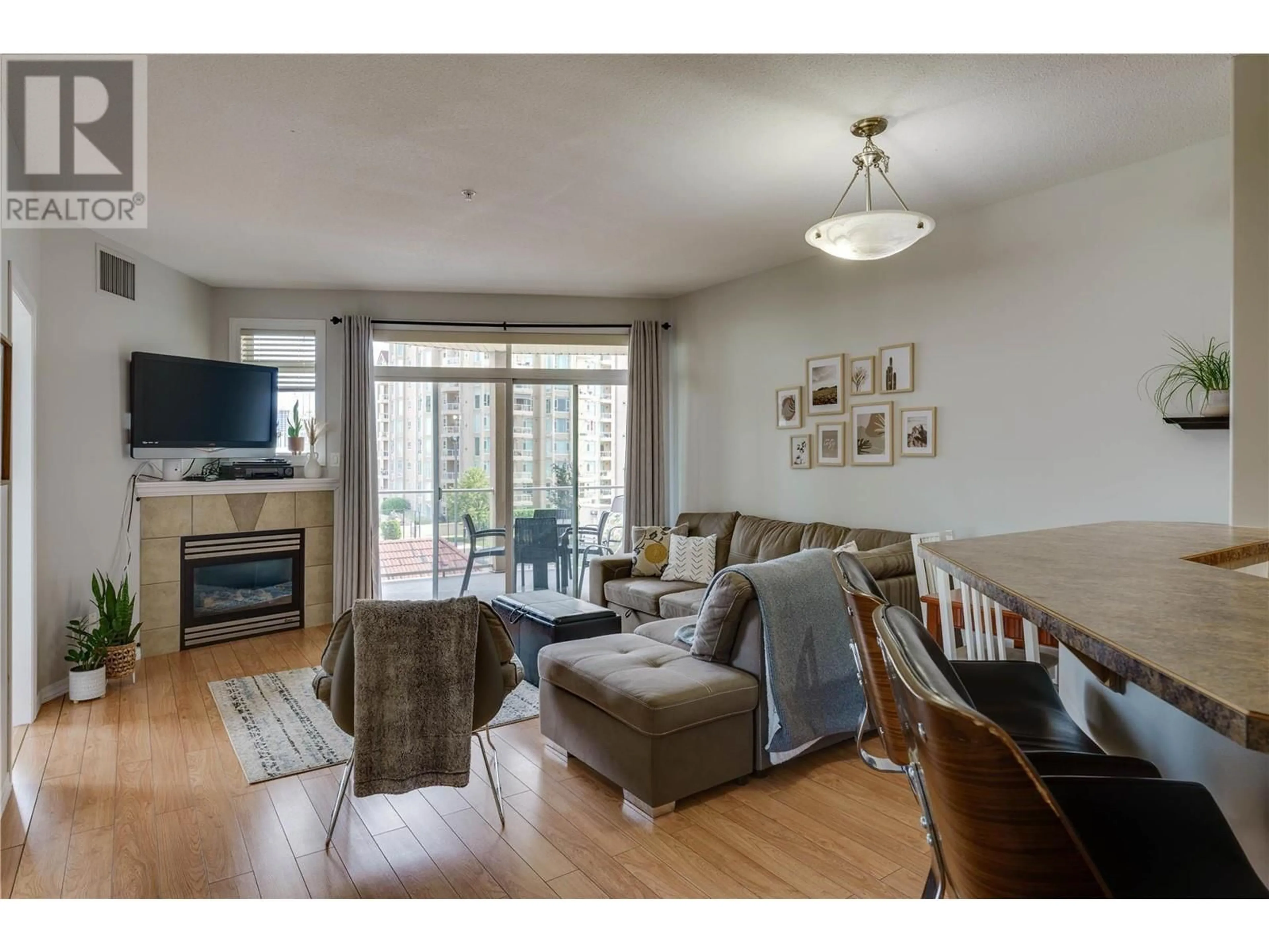 Living room with furniture, wood/laminate floor for 542 - 1088 SUNSET DRIVE, Kelowna British Columbia V1Y9W1