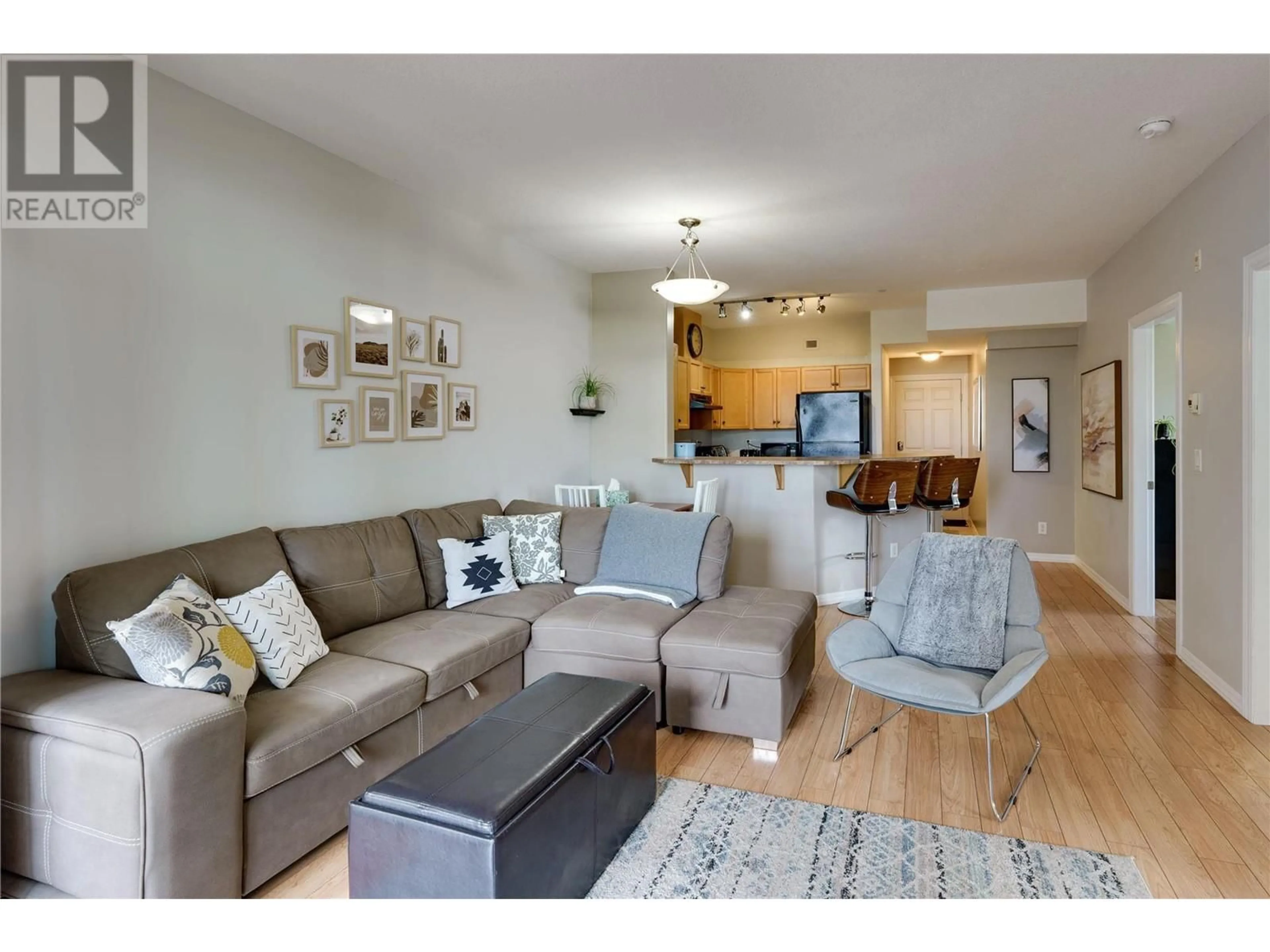 Living room with furniture, wood/laminate floor for 542 - 1088 SUNSET DRIVE, Kelowna British Columbia V1Y9W1