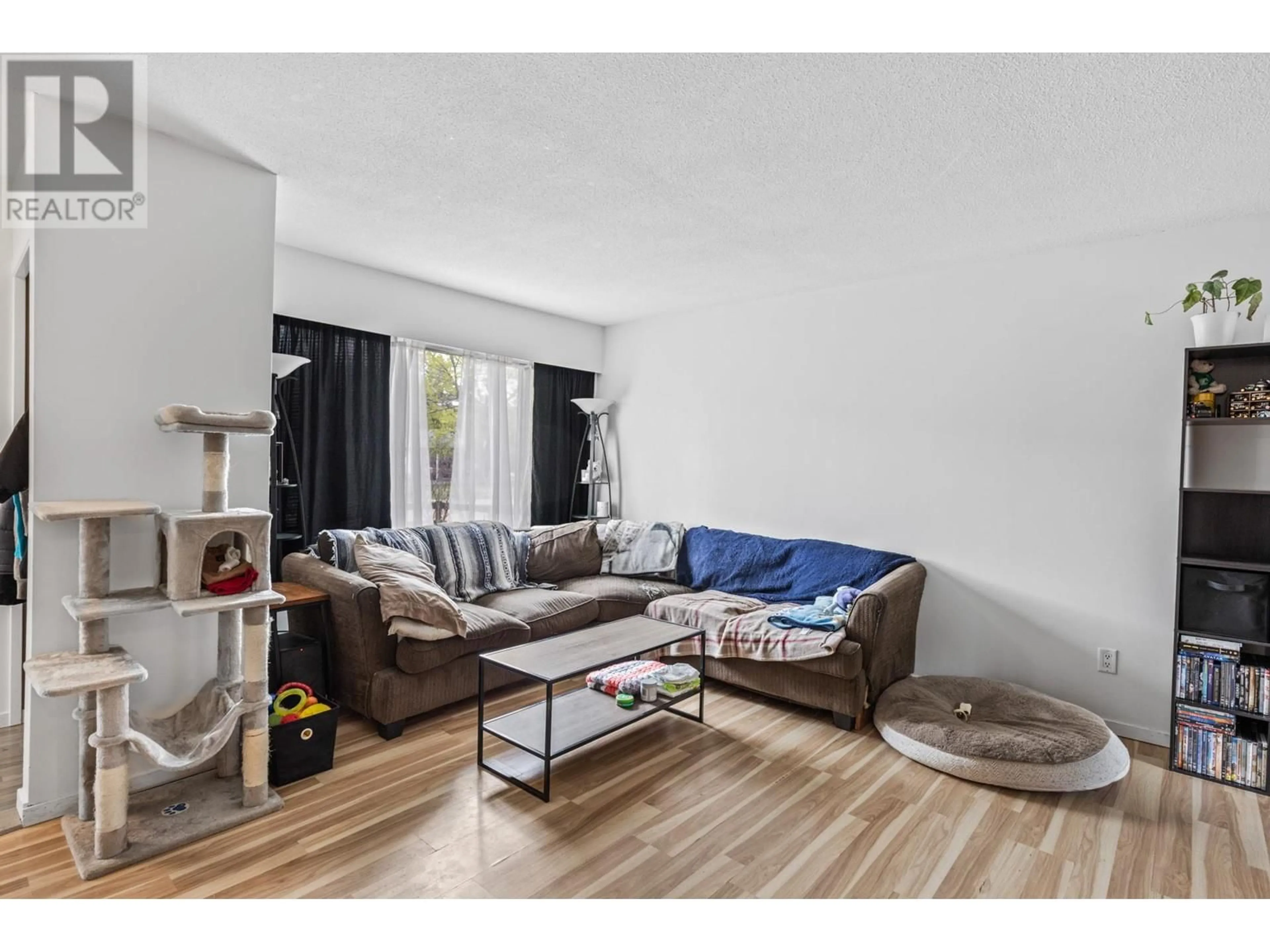 Living room with furniture, wood/laminate floor for 690 BELL ROAD, Kelowna British Columbia V1X2Y1