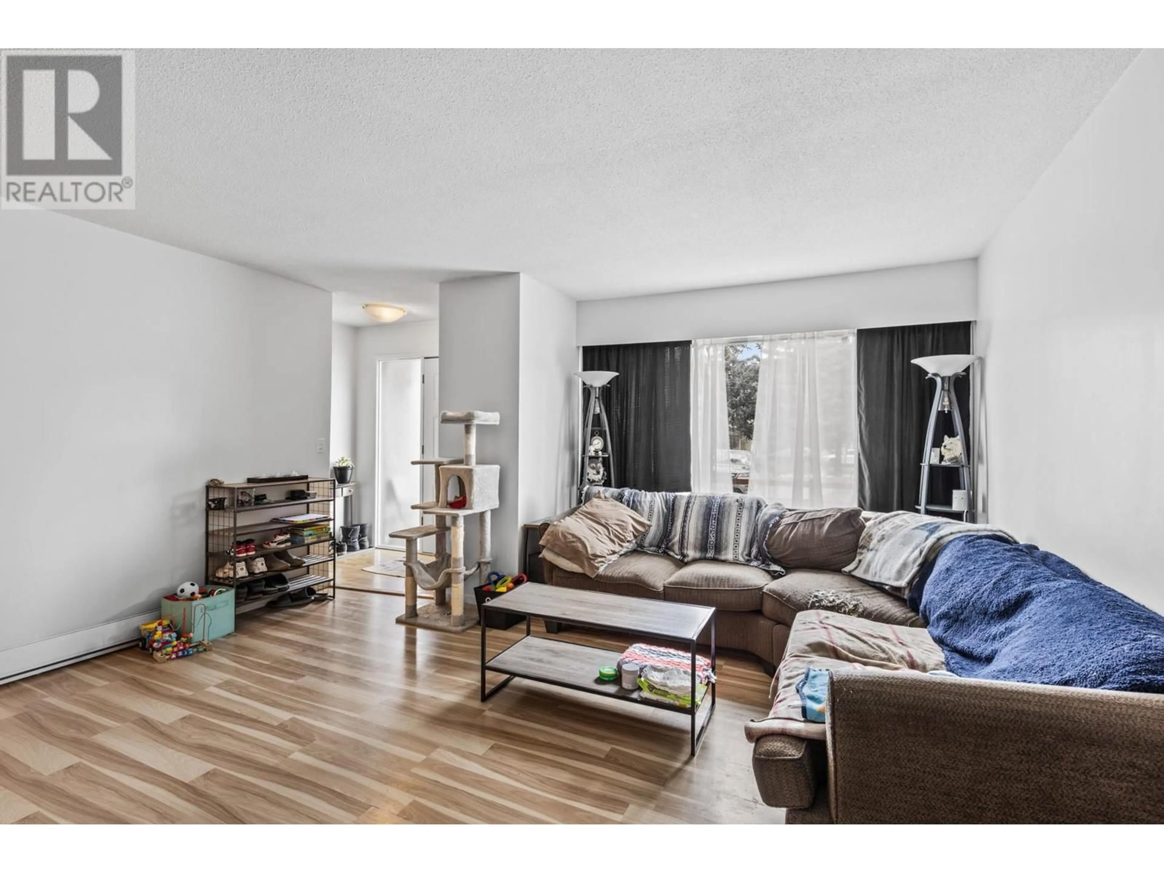Living room with furniture, wood/laminate floor for 690 BELL ROAD, Kelowna British Columbia V1X2Y1