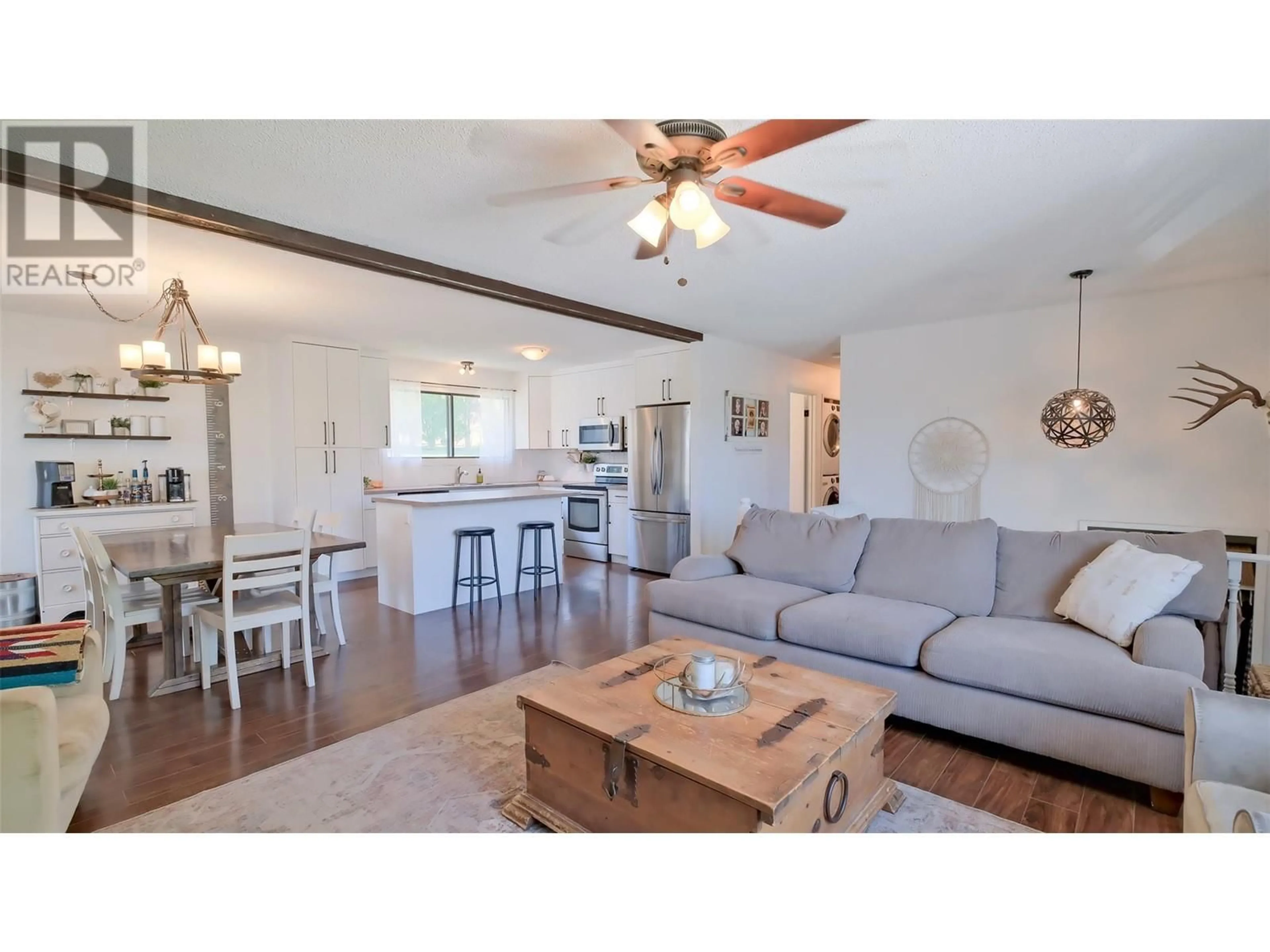 Living room with furniture, wood/laminate floor for 2214 LYNRICK ROAD, Kelowna British Columbia V1P1G4