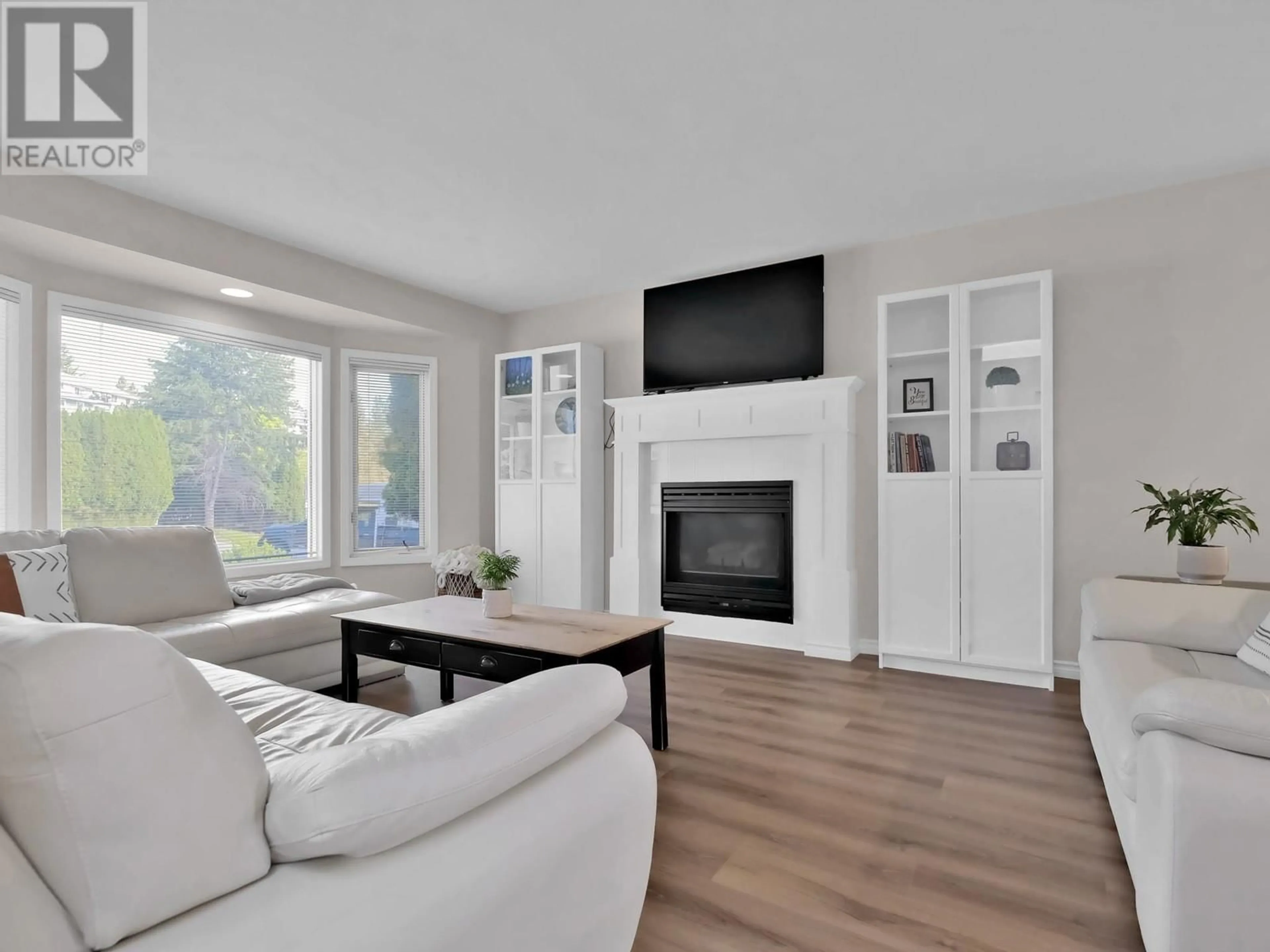 Living room with furniture, wood/laminate floor for 763 CASSIAR COURT, Kelowna British Columbia V1V1M7