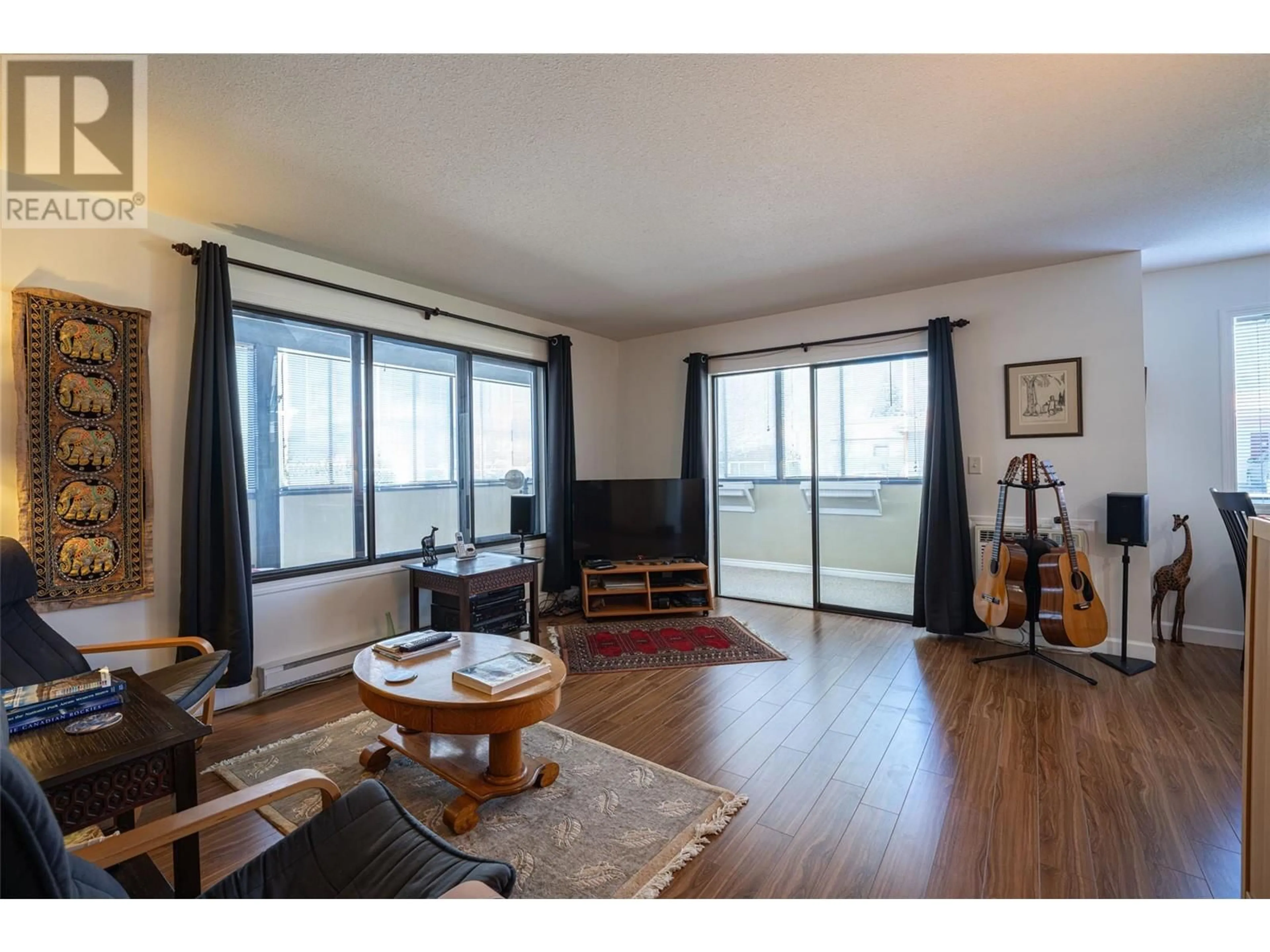 Living room with furniture, wood/laminate floor for 120 - 2085 GORDON DRIVE, Kelowna British Columbia V1Y8S1