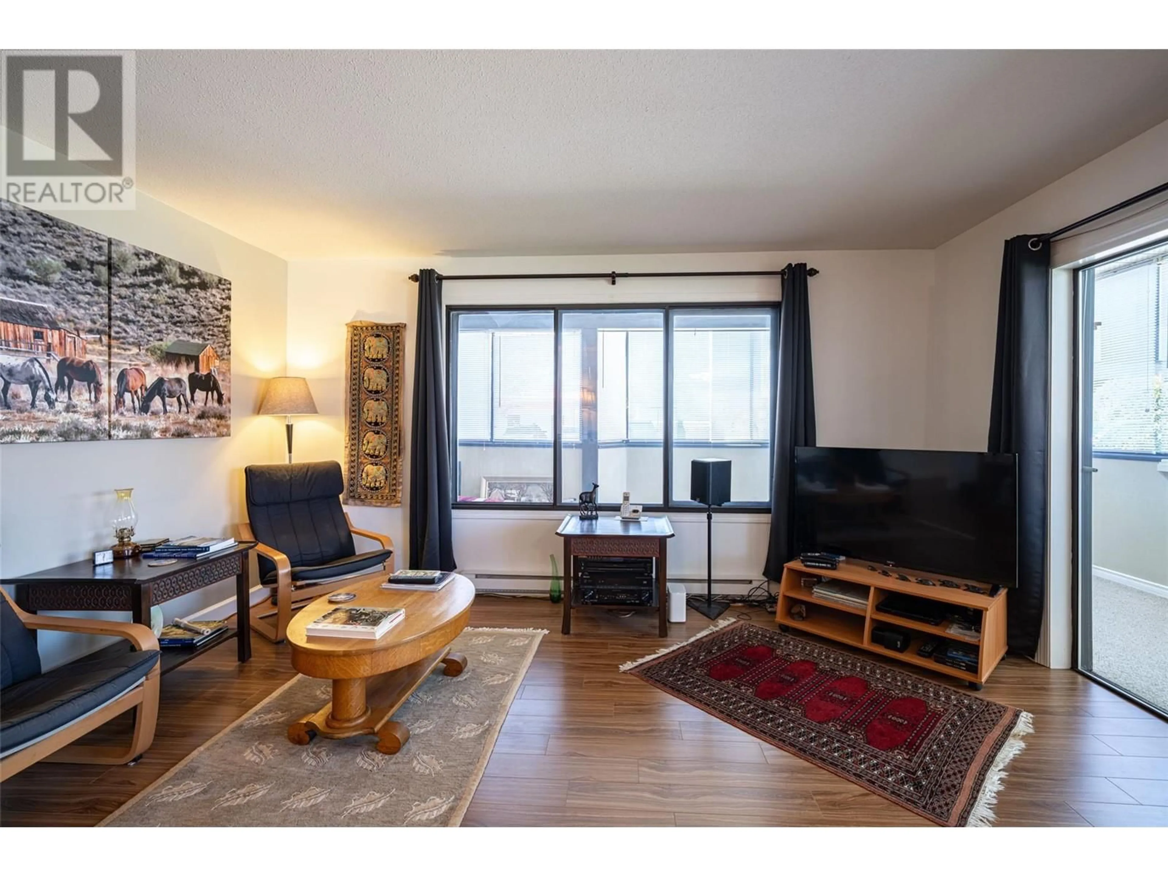 Living room with furniture, wood/laminate floor for 120 - 2085 GORDON DRIVE, Kelowna British Columbia V1Y8S1
