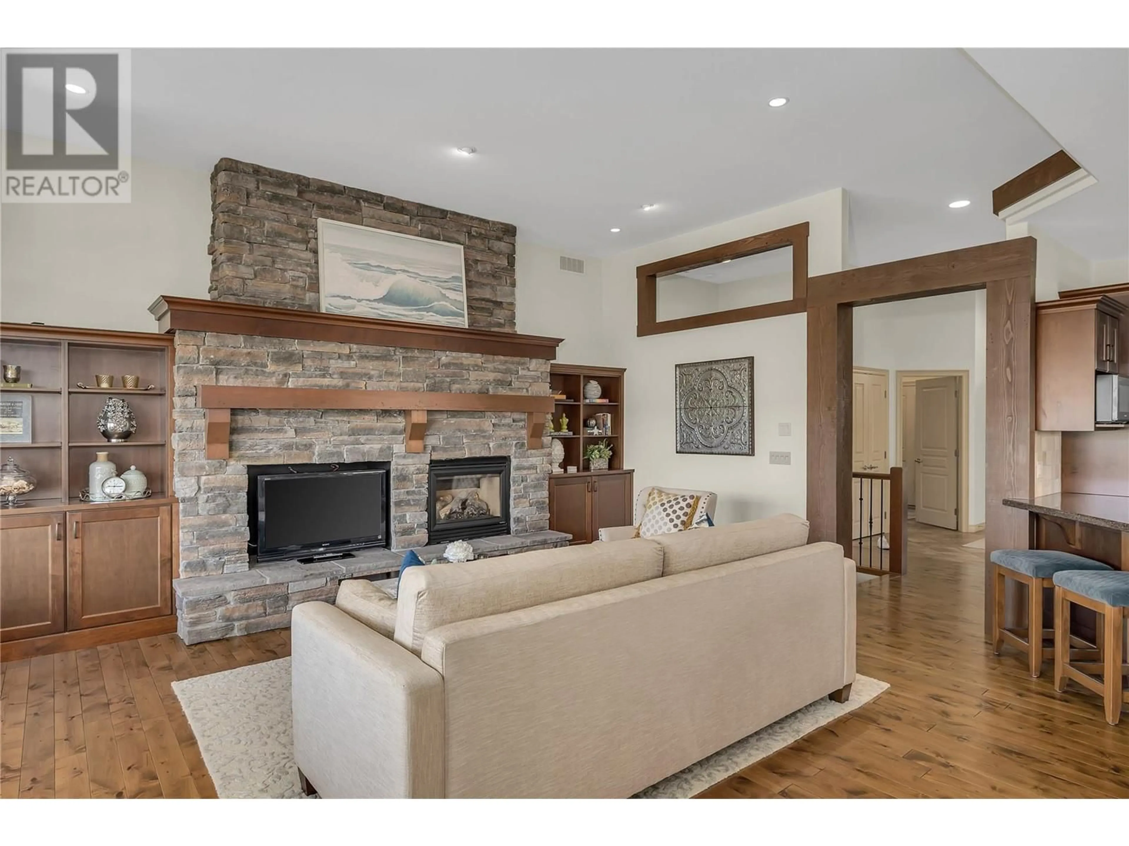 Living room with furniture, wood/laminate floor for 2037 CAPISTRANO DRIVE, Kelowna British Columbia V1V2N1