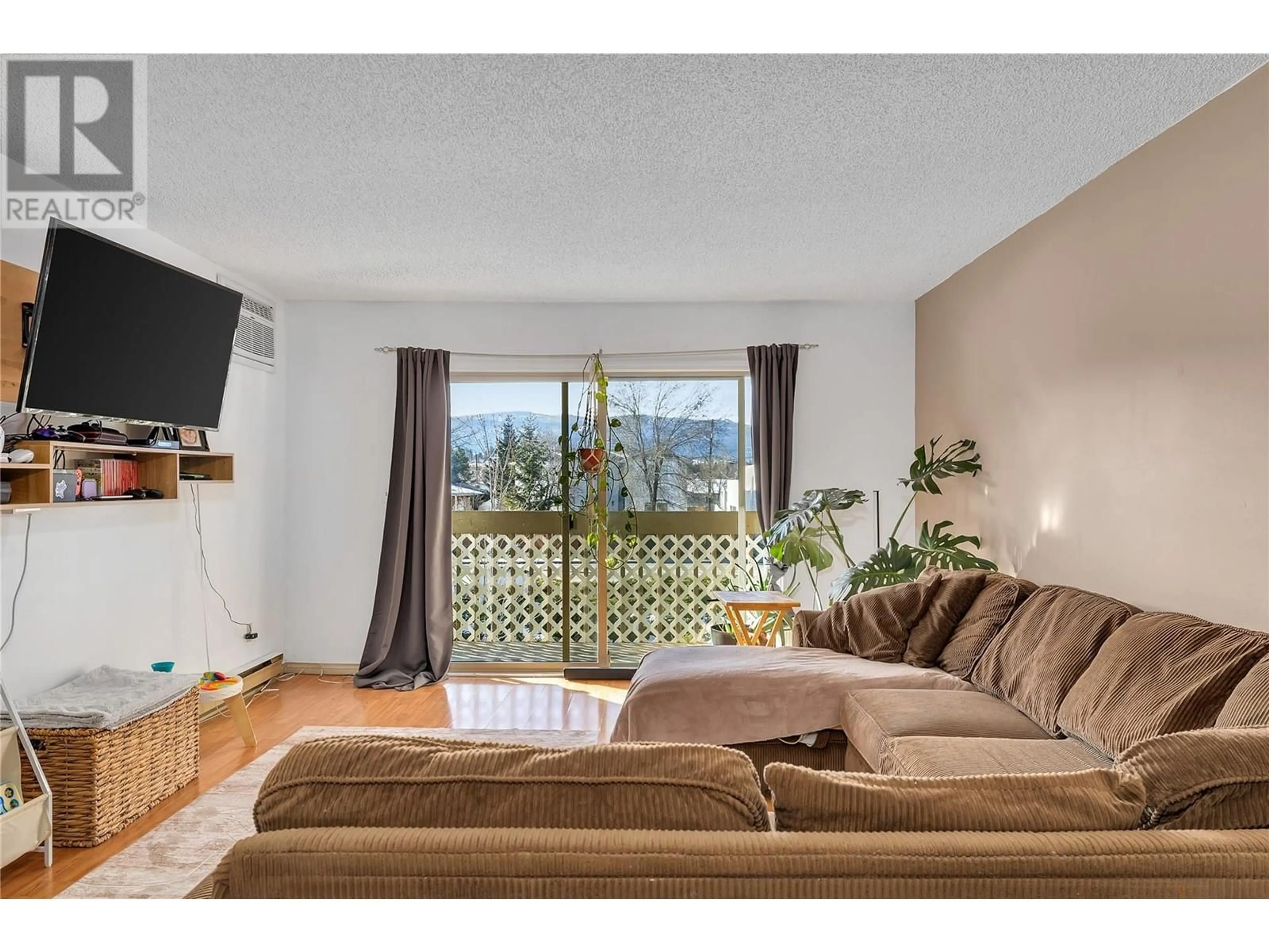 Living room with furniture, wood/laminate floor for 206 - 290 HIGHWAY 33 OTHER EAST, Kelowna British Columbia V1X2A3