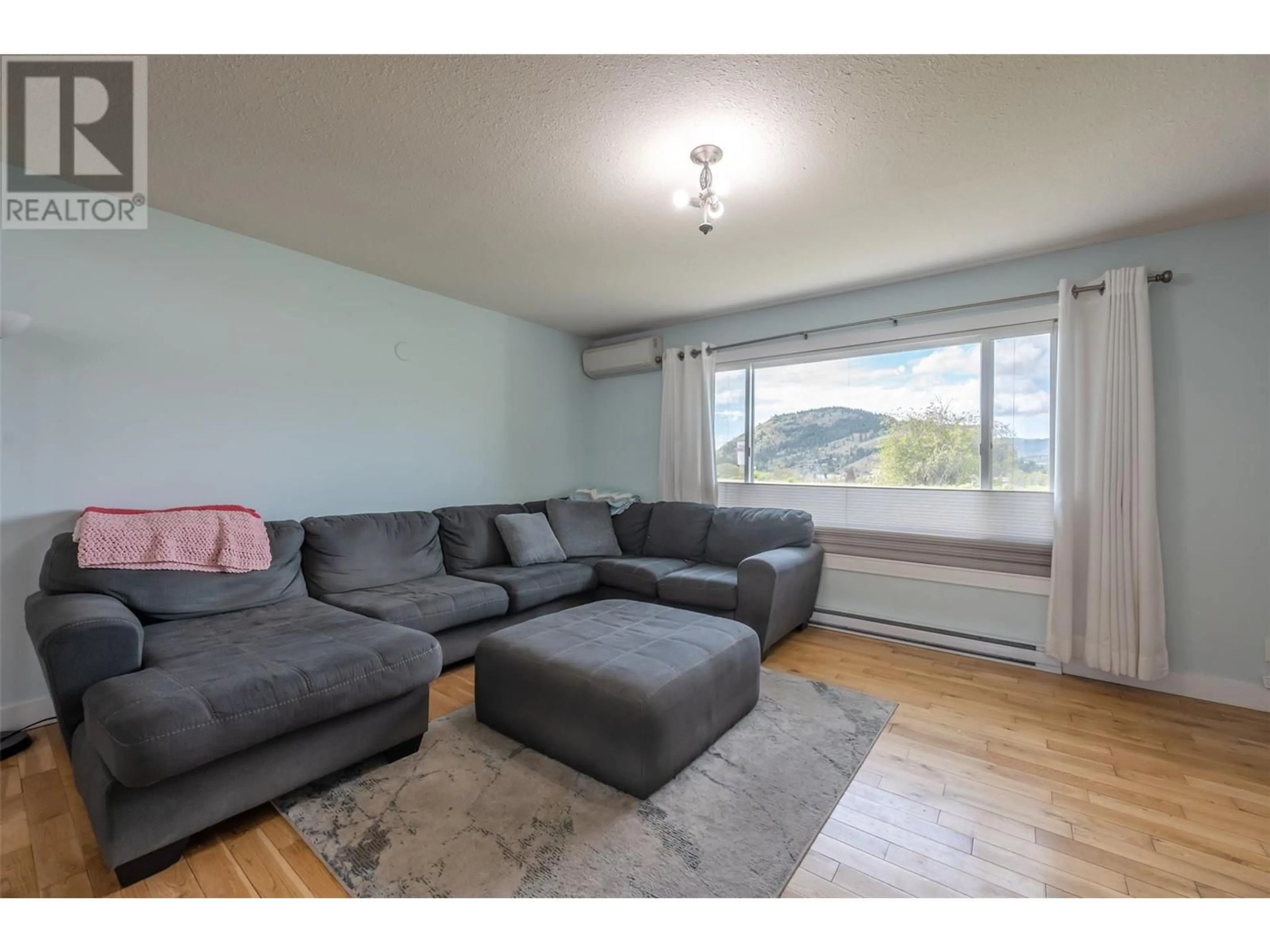 Living room with furniture, wood/laminate floor for 9716 THOMPSON ROAD, Summerland British Columbia V0H1Z3