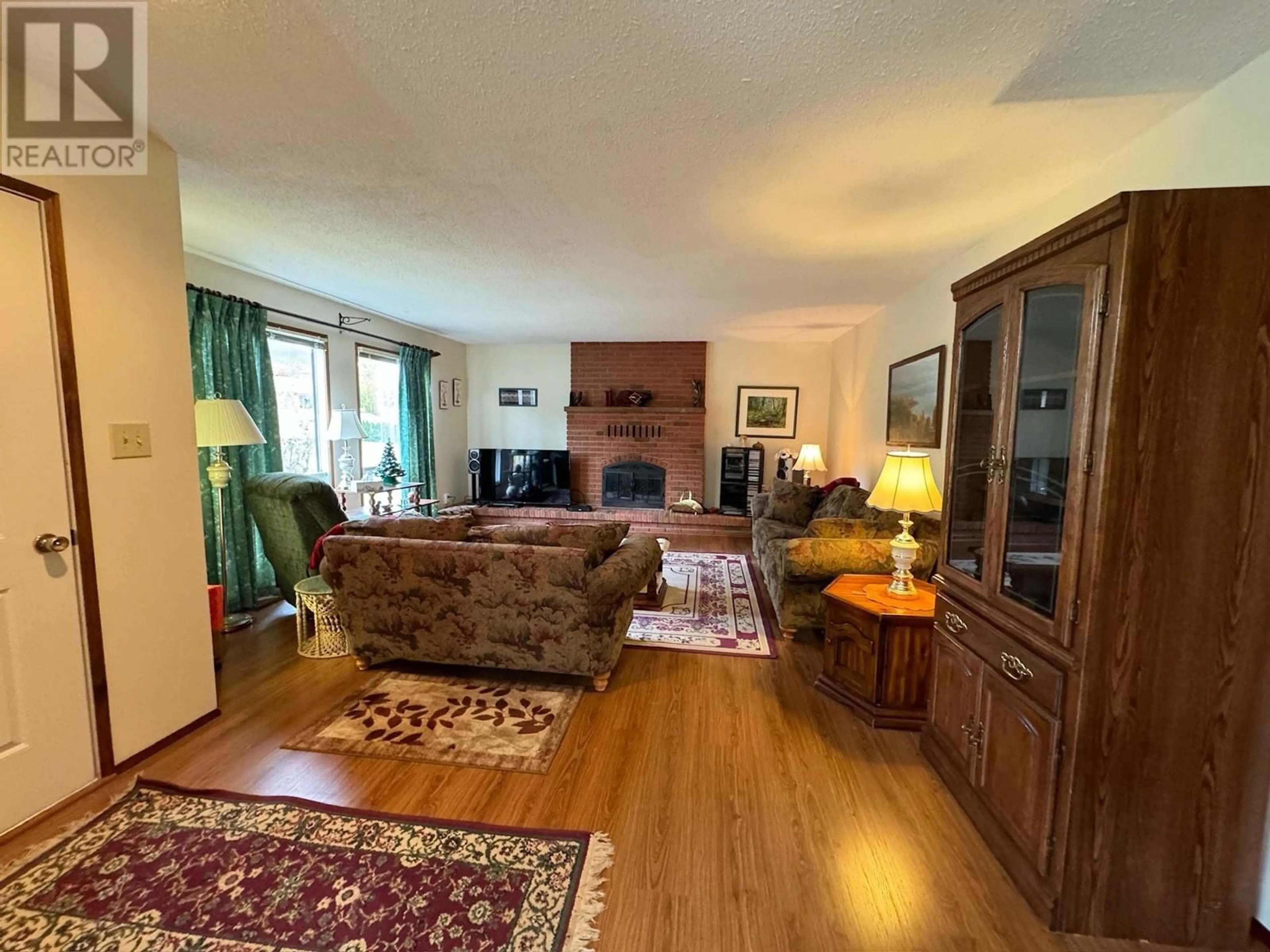Living room with furniture, wood/laminate floor for 10417 VICTORIA ROAD SOUTH, Summerland British Columbia V0H1Z2