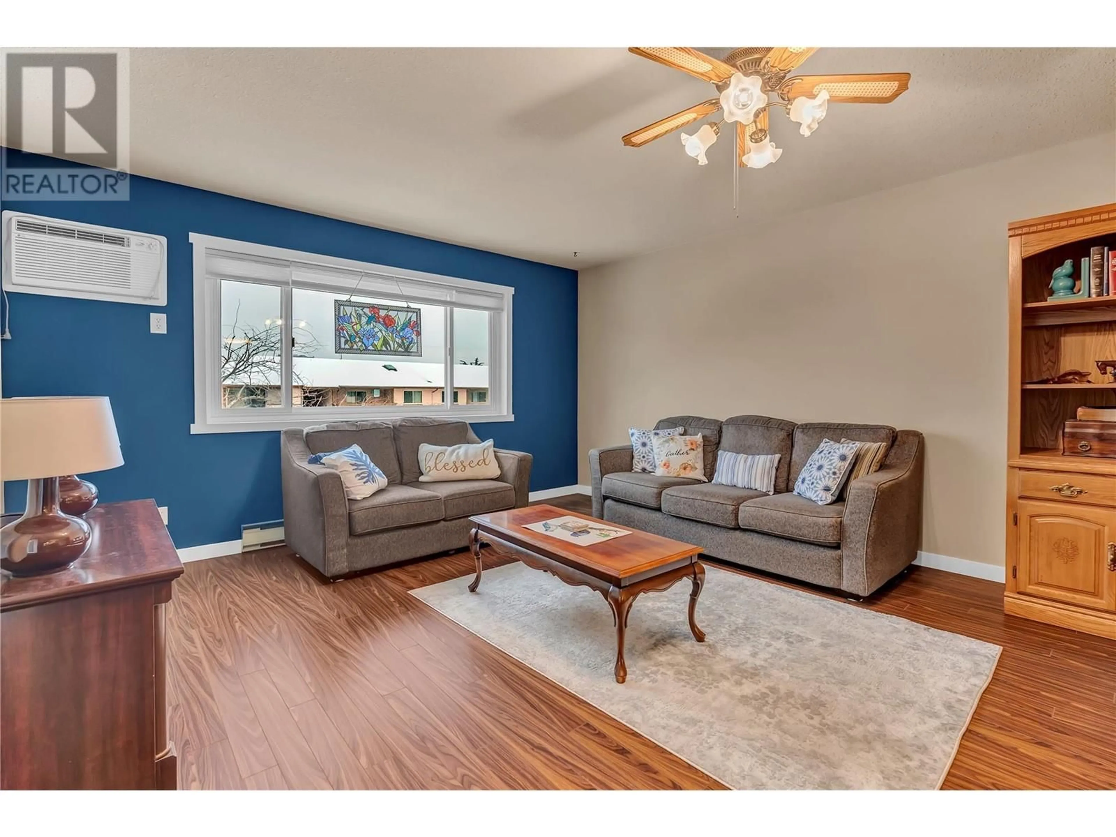 Living room with furniture, wood/laminate floor for 207 - 1820 ATKINSON STREET, Penticton British Columbia V2A7M6