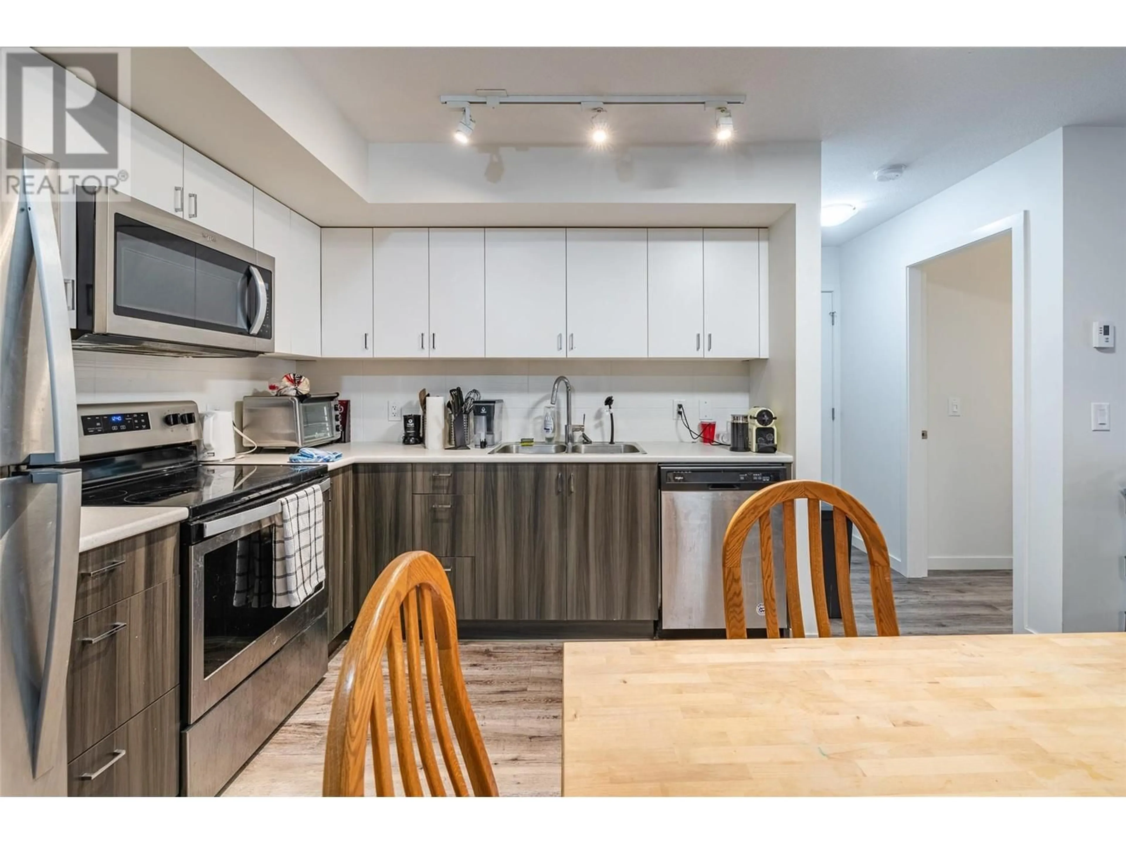 Open concept kitchen, wood/laminate floor for 110 - 655 ACADEMY WAY, Kelowna British Columbia V1V3A4