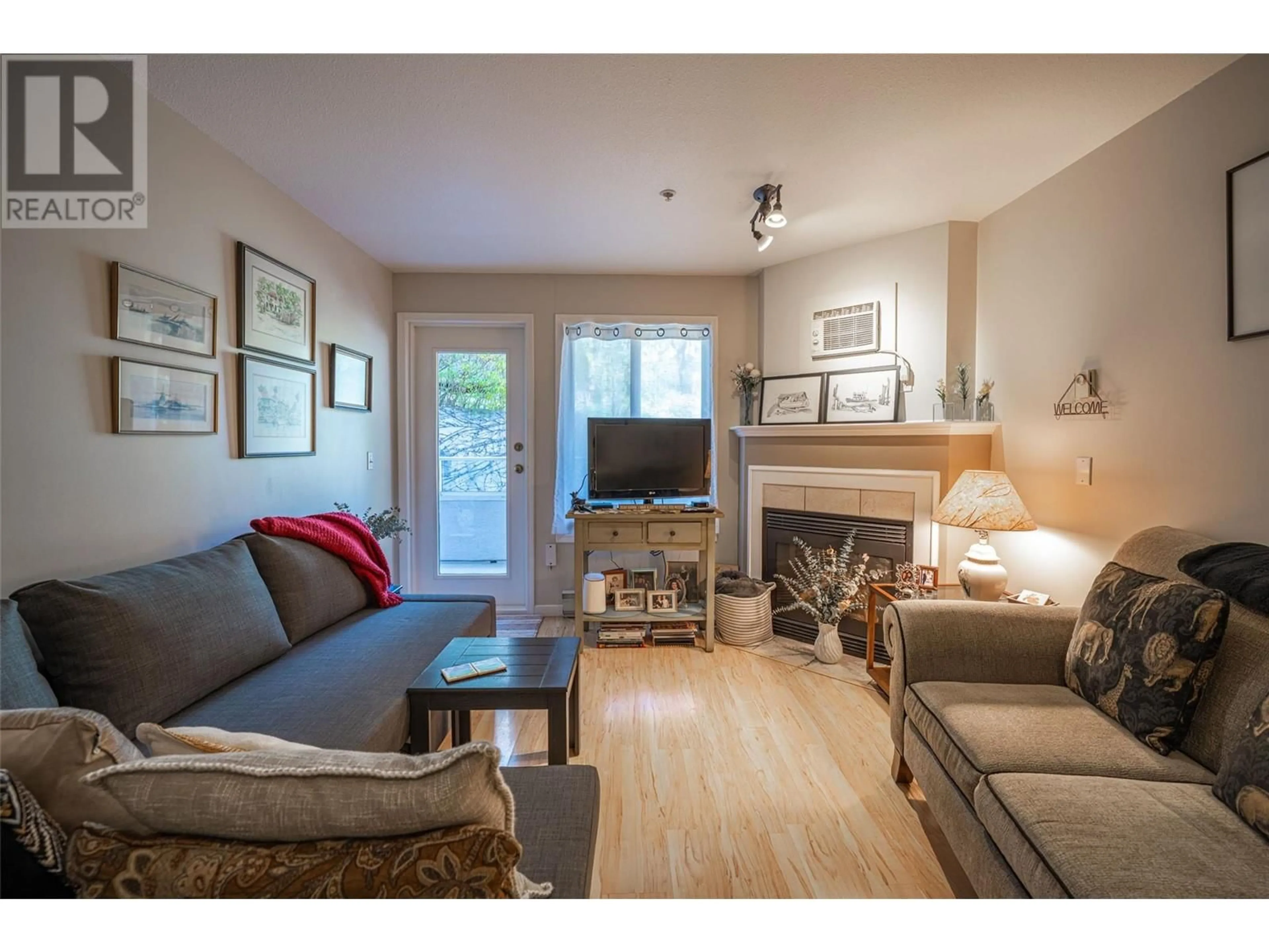 Living room with furniture, wood/laminate floor for 206 - 3320 CENTENNIAL DRIVE, Vernon British Columbia V1T9M4