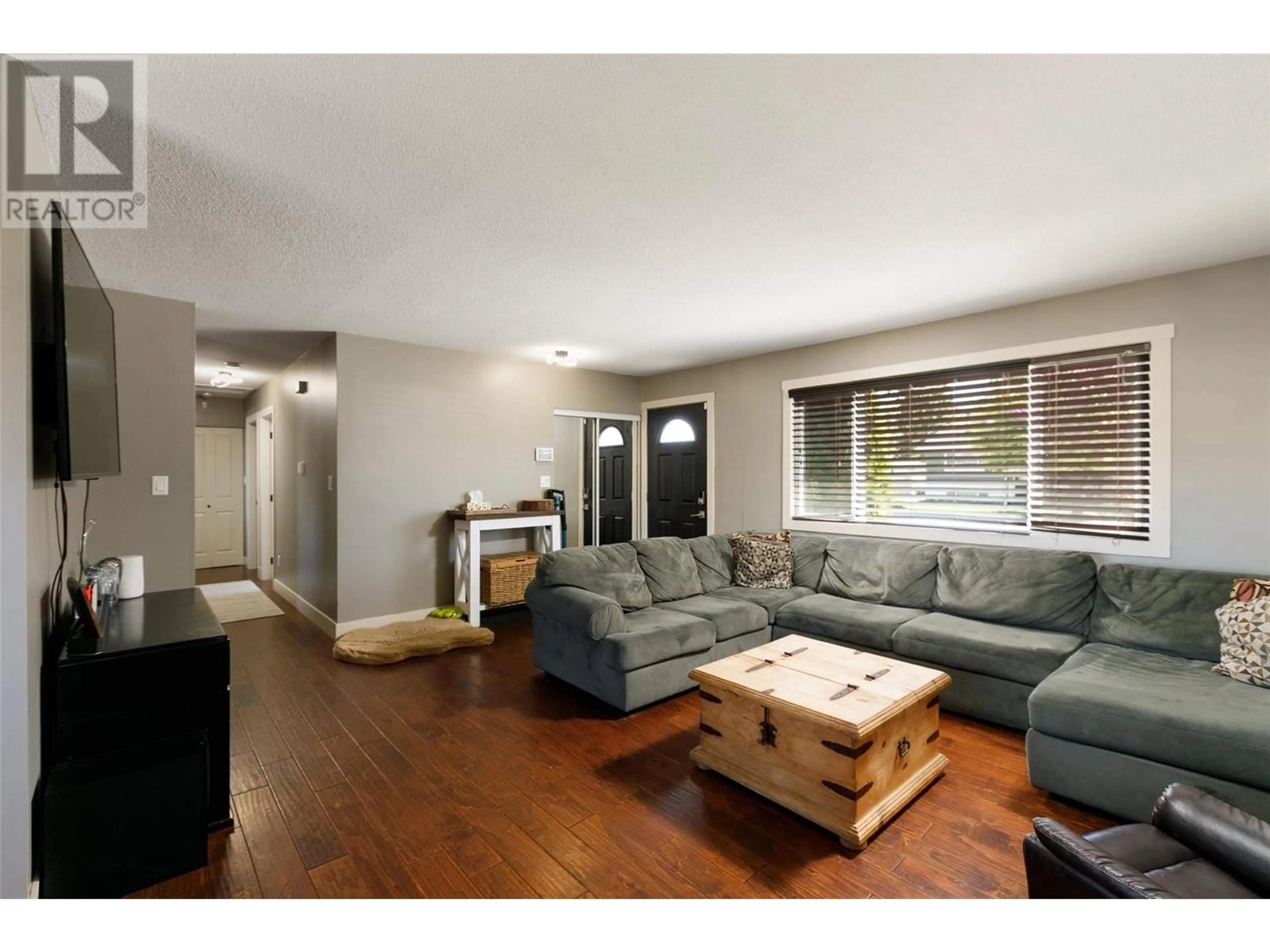 Living room with furniture, wood/laminate floor for 250 DUNDAS ROAD, Kelowna British Columbia V1X3X7