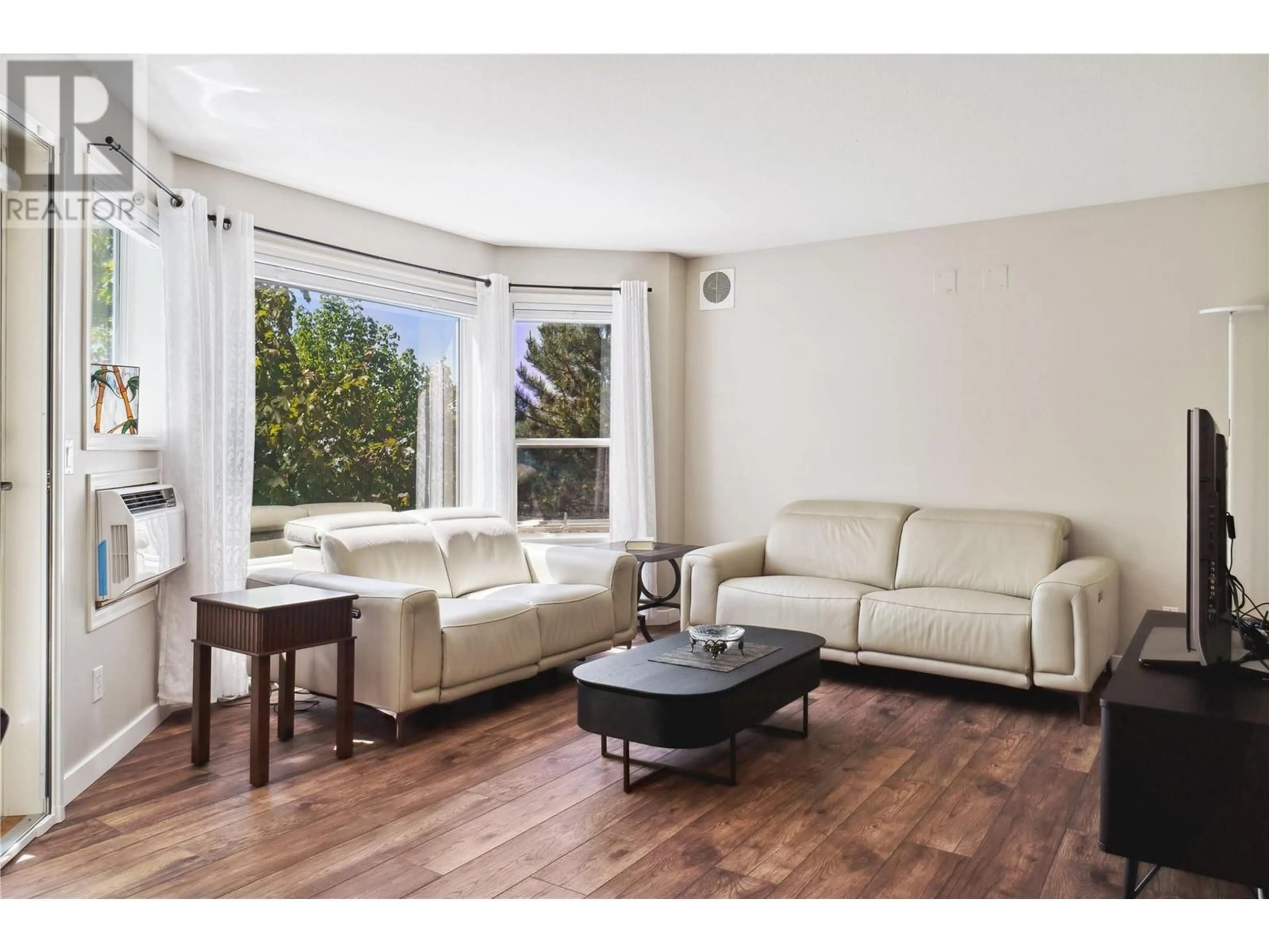 Living room with furniture, wood/laminate floor for 202 - 3283 CASORSO ROAD, Kelowna British Columbia V1W3L6