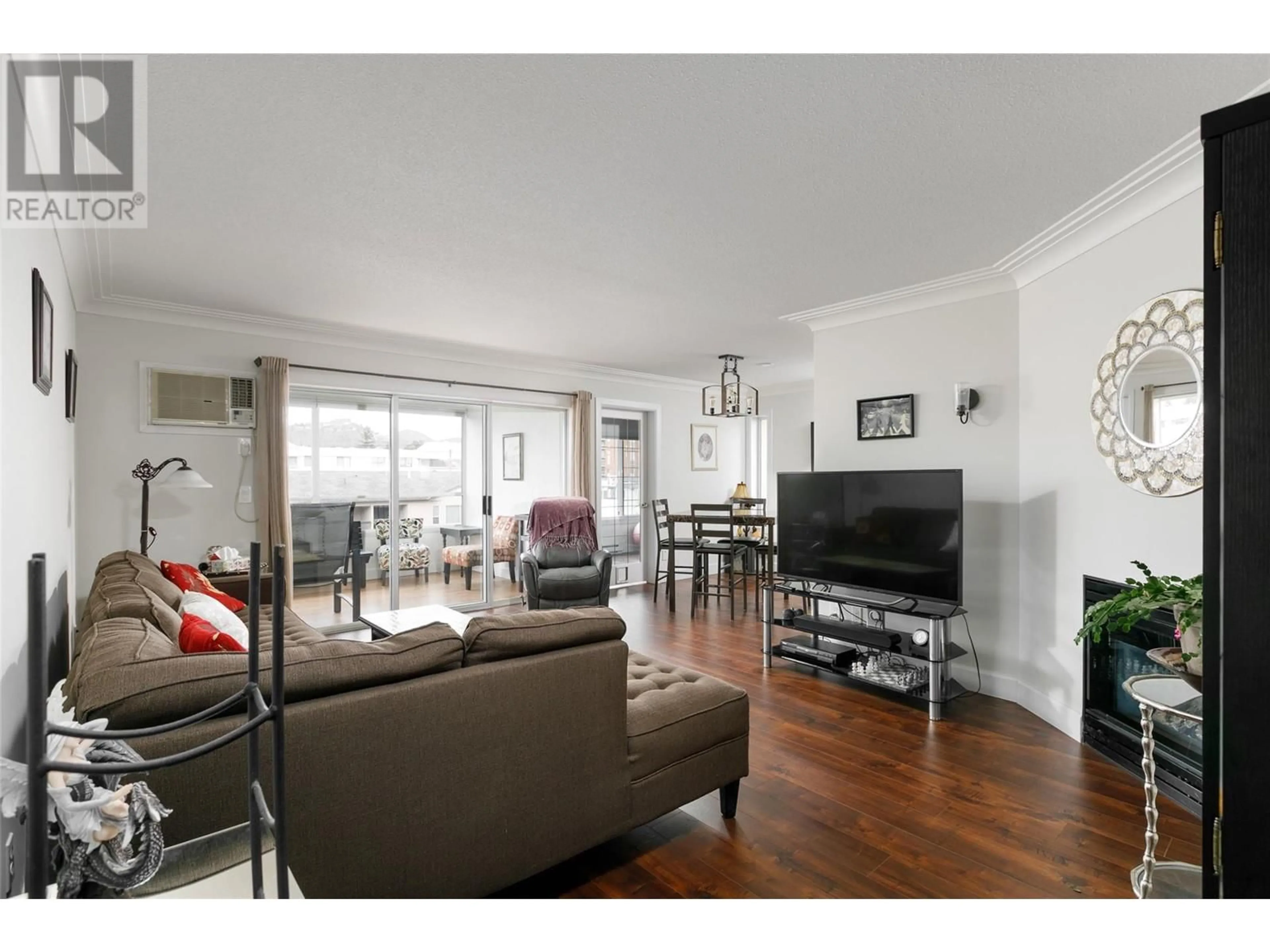 Living room with furniture, wood/laminate floor for 202 - 1055 LAWRENCE AVENUE, Kelowna British Columbia V1Y6M3