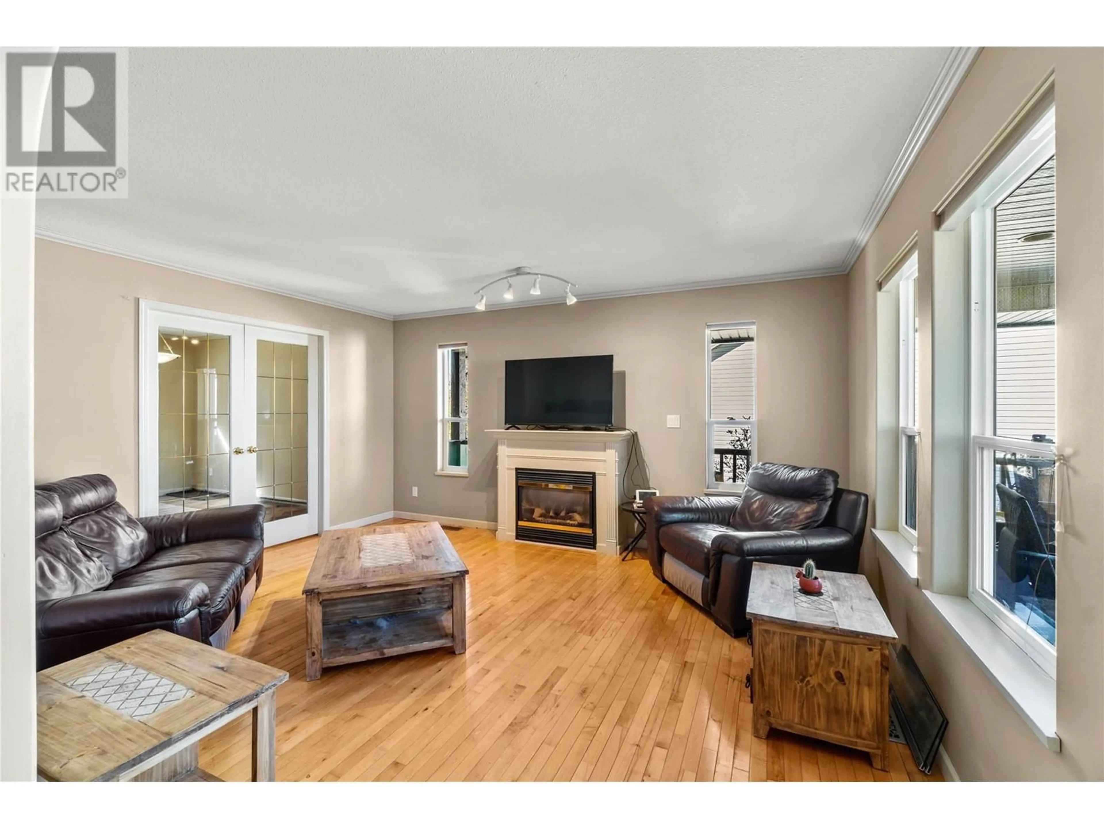 Living room with furniture, wood/laminate floor for 4942 WOODLAND COURT, Kamloops British Columbia V2C6V5