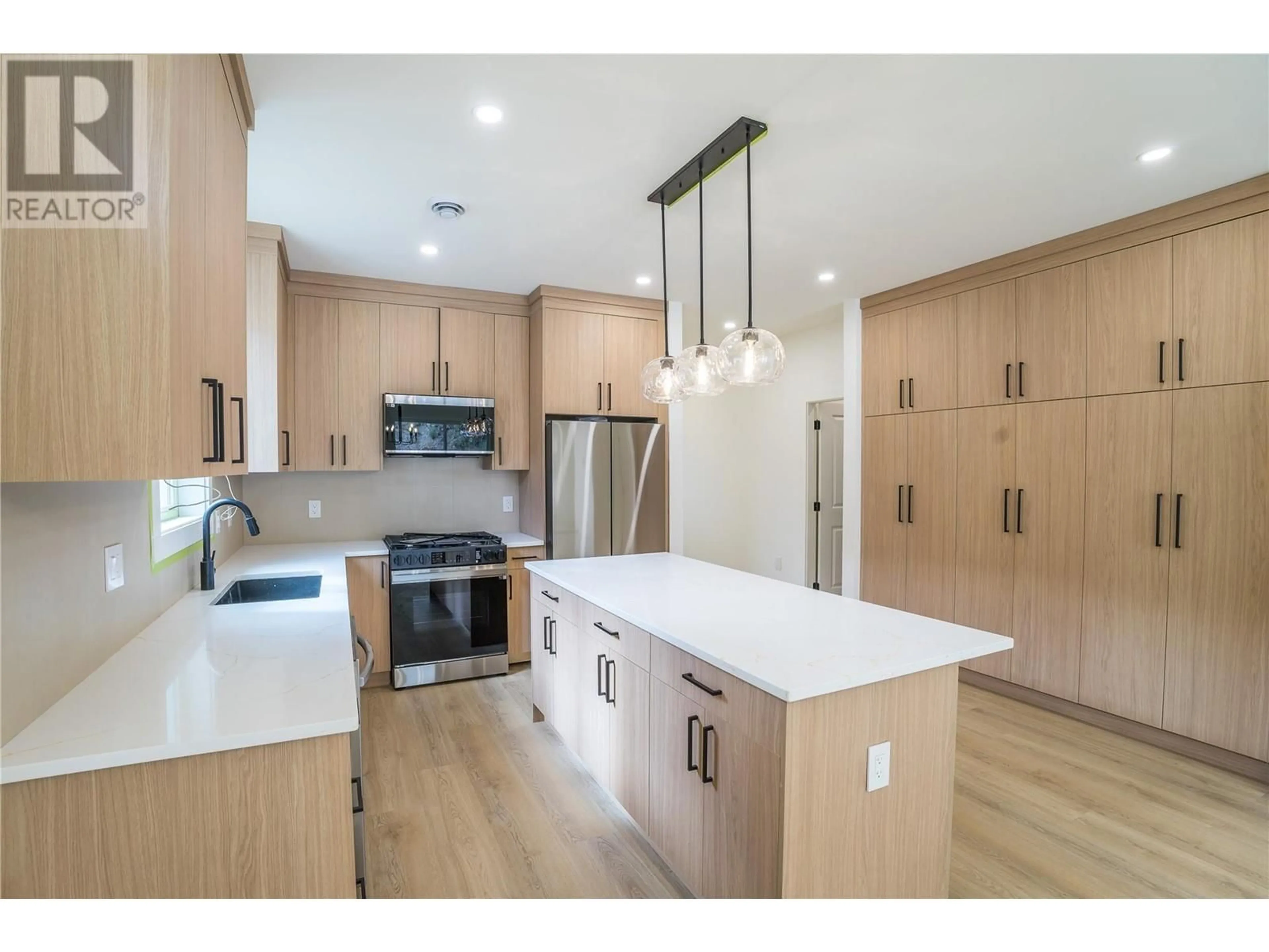 Open concept kitchen, wood/laminate floor for 285 BENTGRASS AVENUE, Oliver British Columbia V0H1T3