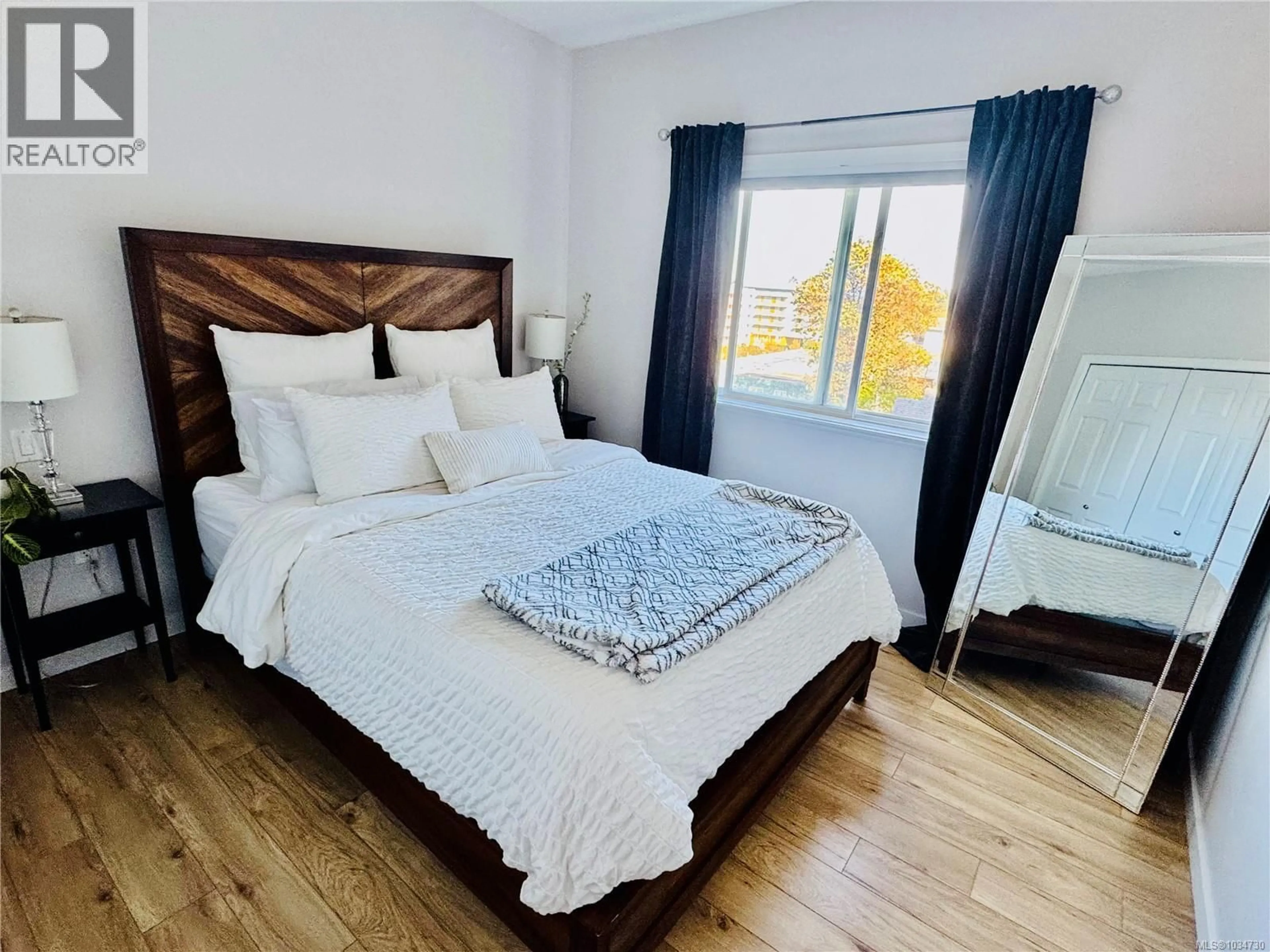 Bedroom with bed, wood/laminate floor for 409 - 360 GOLDSTREAM AVENUE, Colwood British Columbia V9B2W3