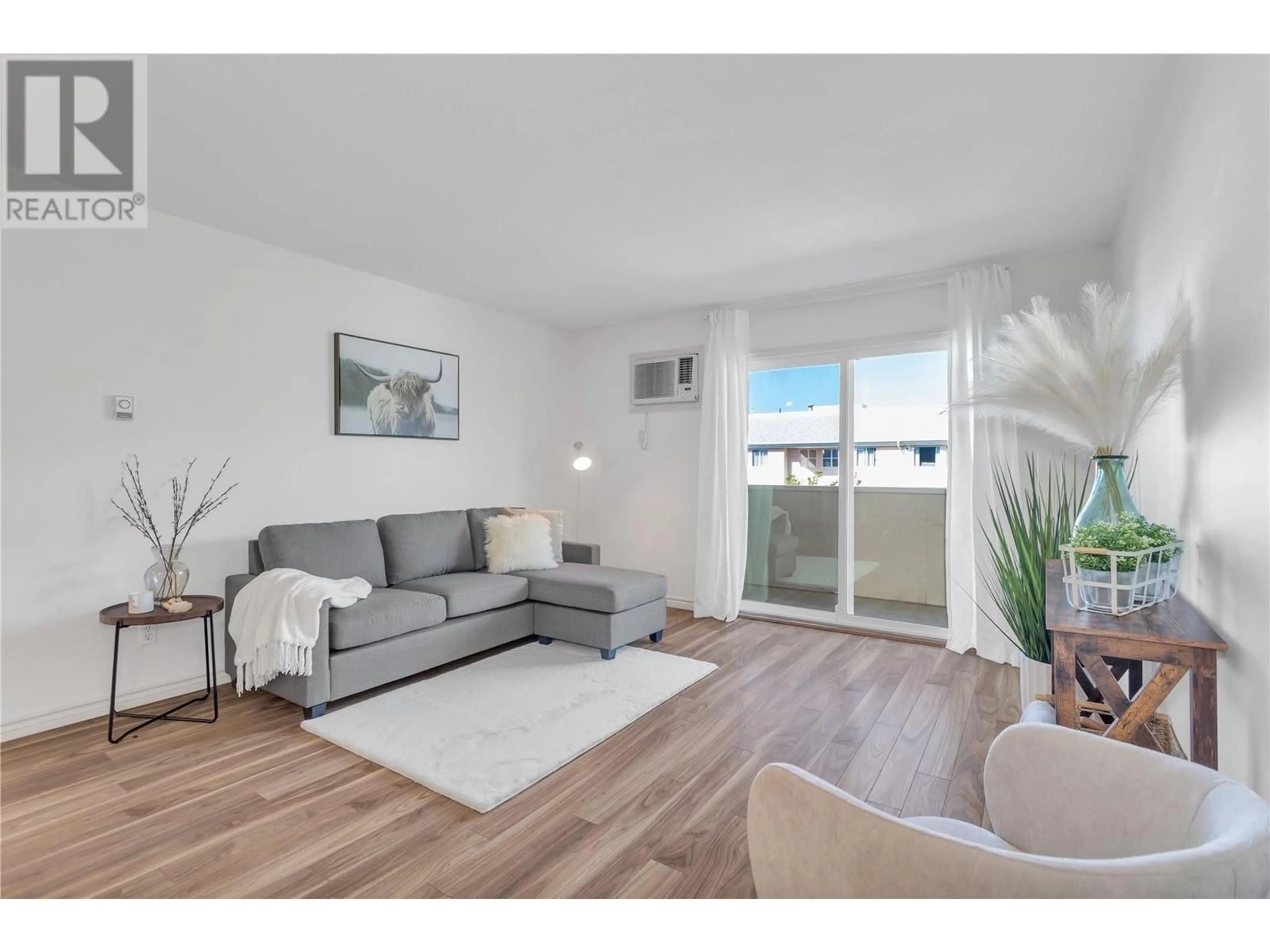 Living room with furniture, wood/laminate floor for 401 - 3160 DE MONTREUIL COURT, Kelowna British Columbia V1W3W3