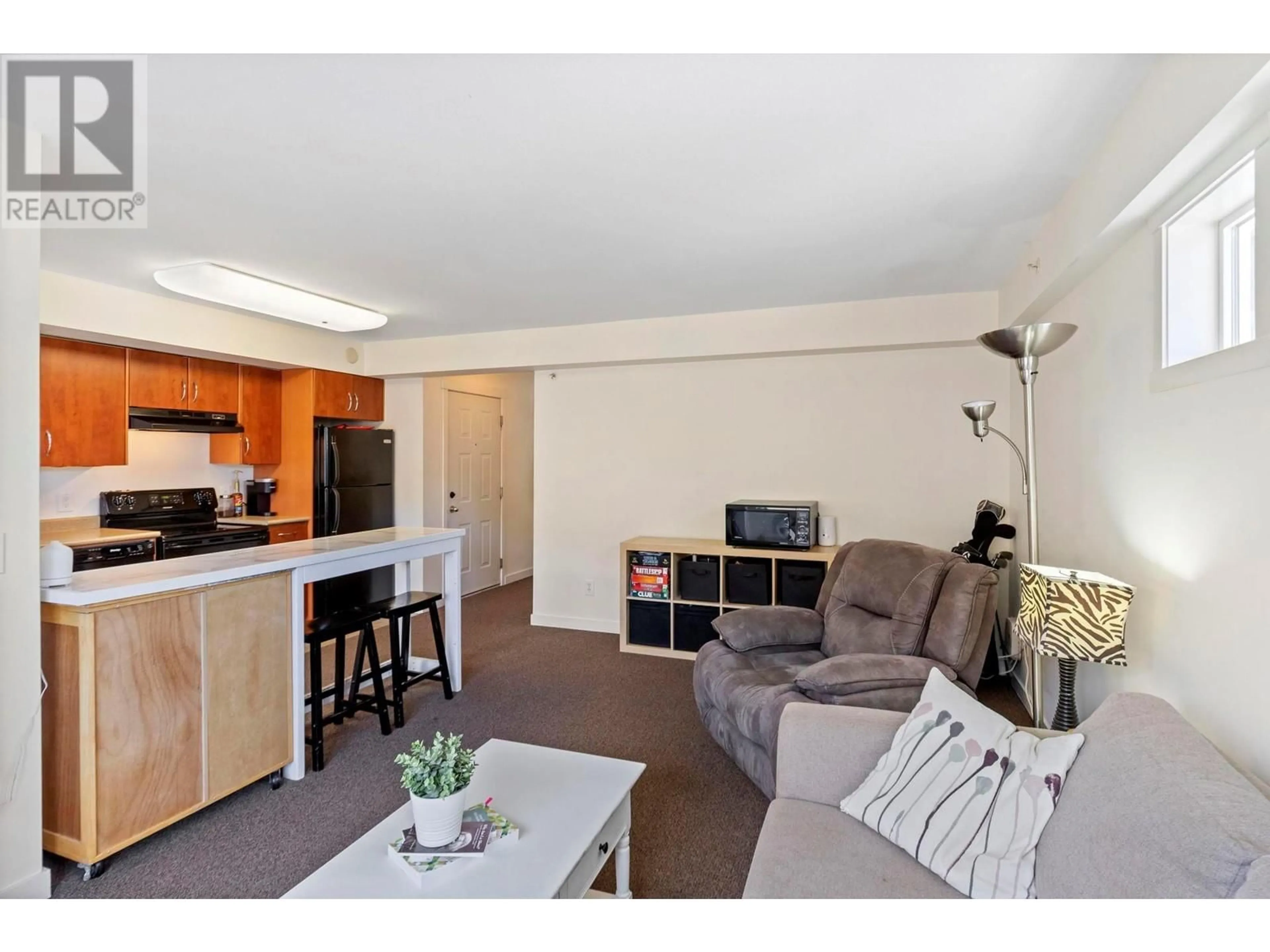 Living room with furniture, wood/laminate floor for 201A - 1475 GLENMORE ROAD NORTH, Kelowna British Columbia V1V2H6