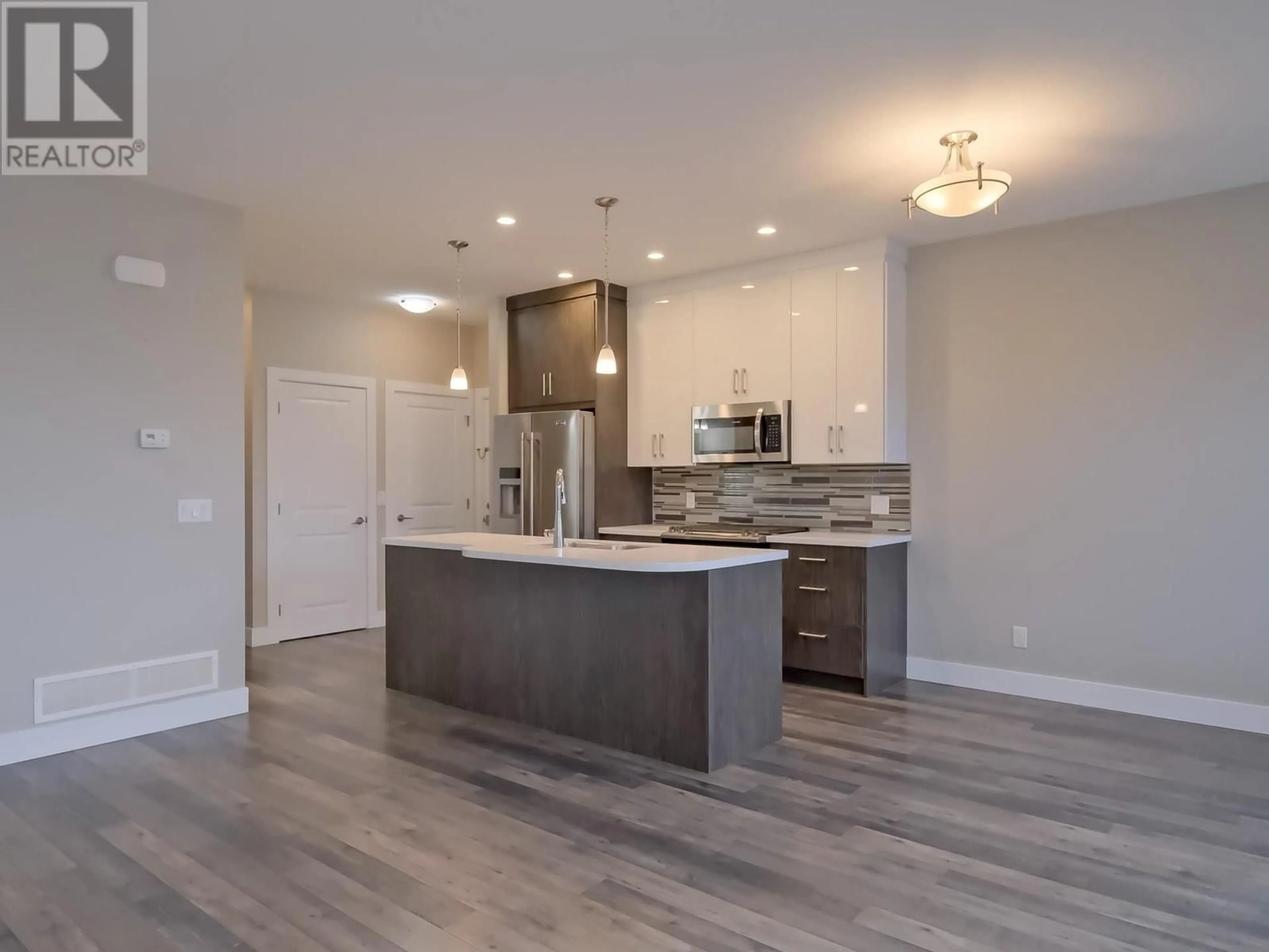 Open concept kitchen, wood/laminate floor for 102 - 704 REVELSTOKE AVENUE, Penticton British Columbia V2A2J2