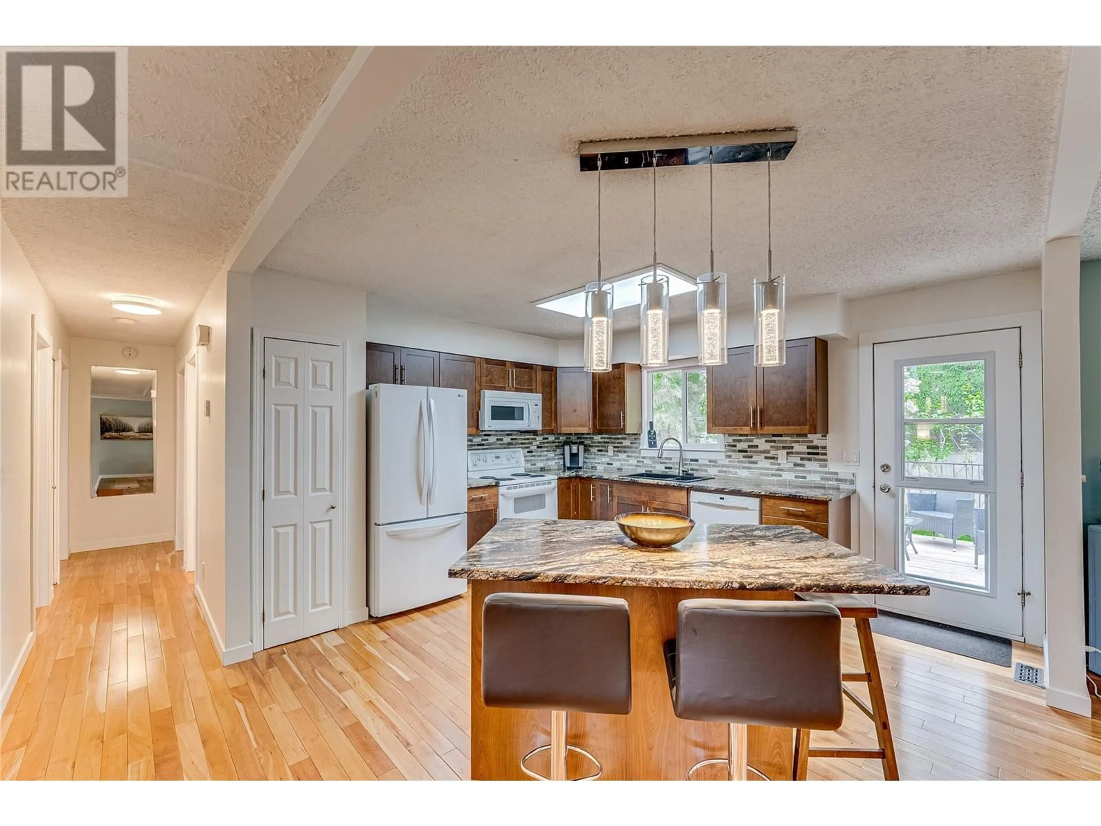 Open concept kitchen, wood/laminate floor for 3911 15 STREET, Vernon British Columbia V1T7S4