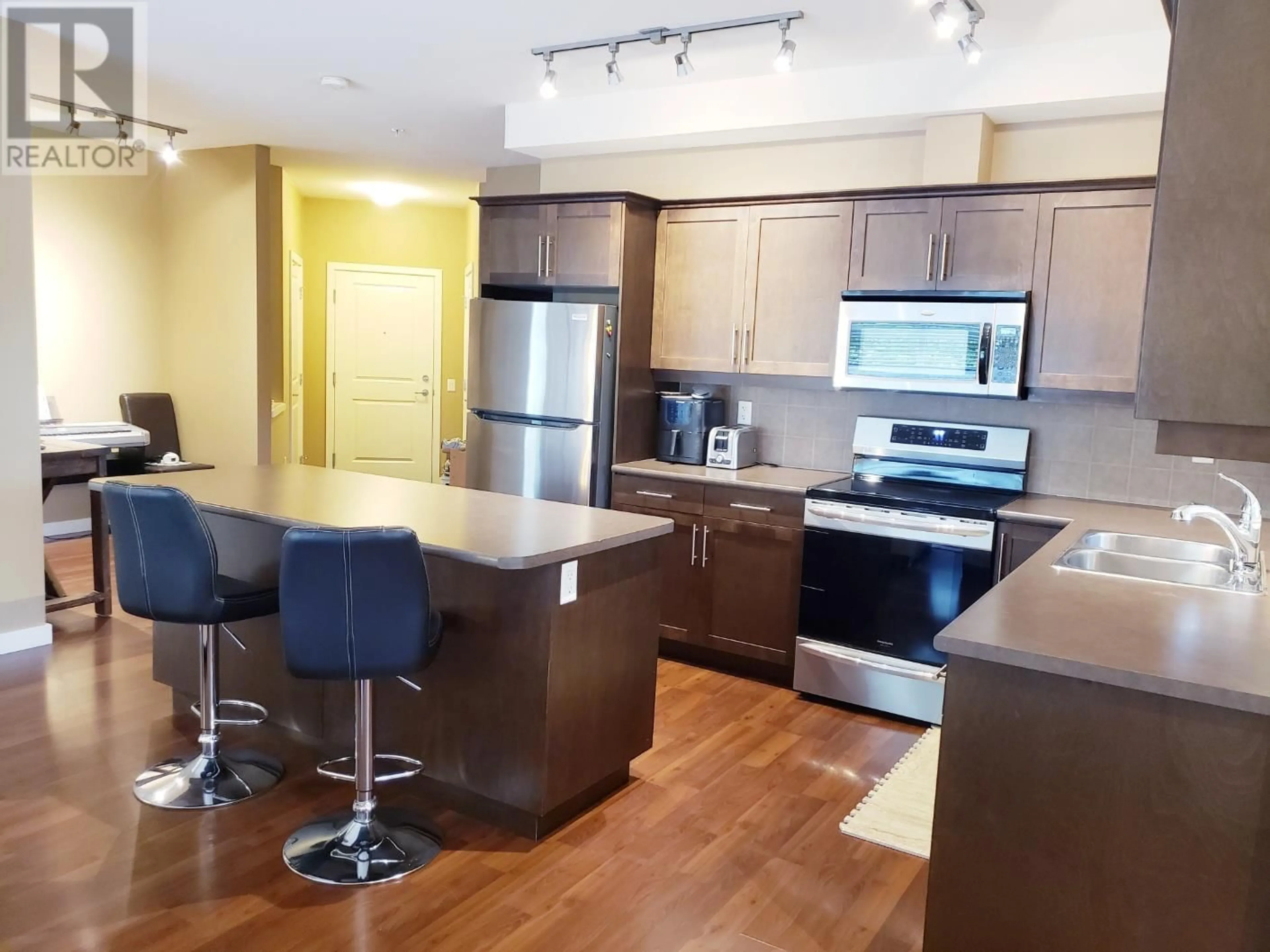 Open concept kitchen, wood/laminate floor for 204 - 151 TAYLOR ROAD, Kelowna British Columbia V1X4G1