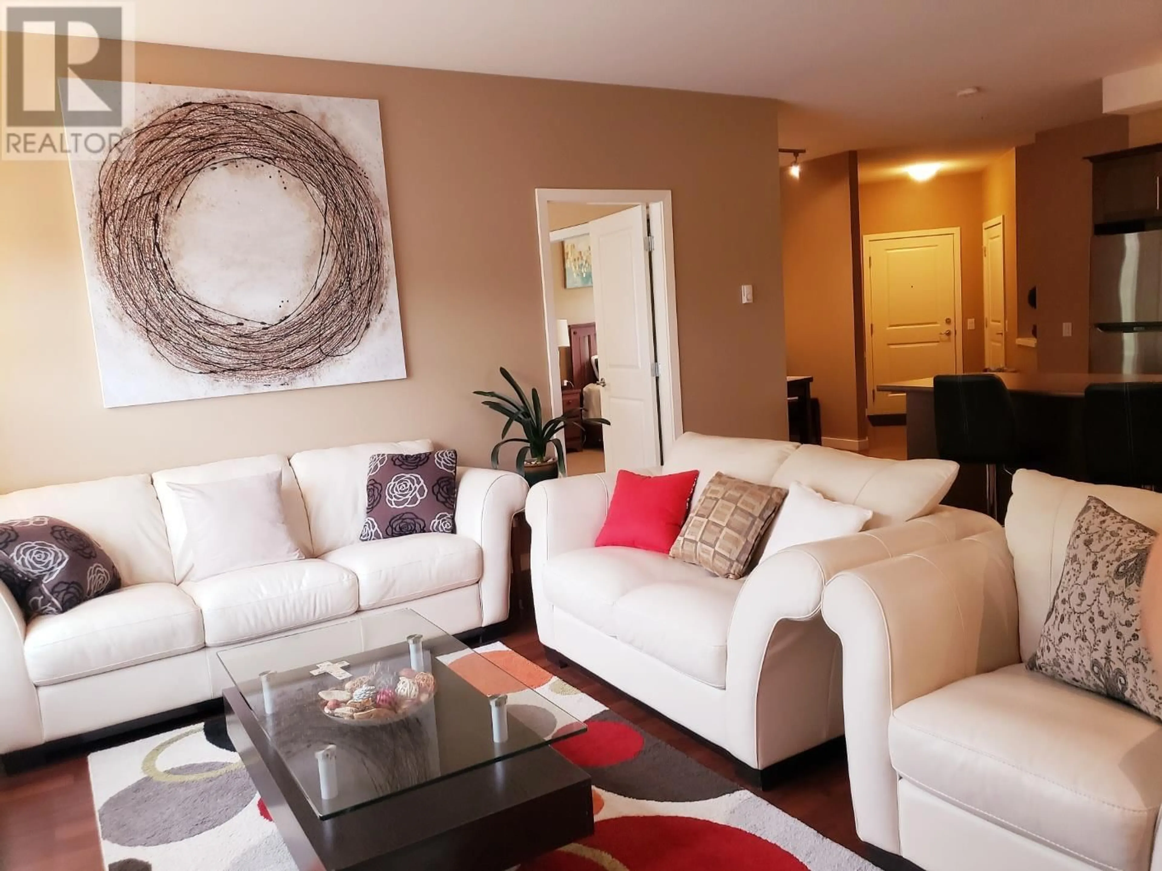Living room with furniture, wood/laminate floor for 204 - 151 TAYLOR ROAD, Kelowna British Columbia V1X4G1