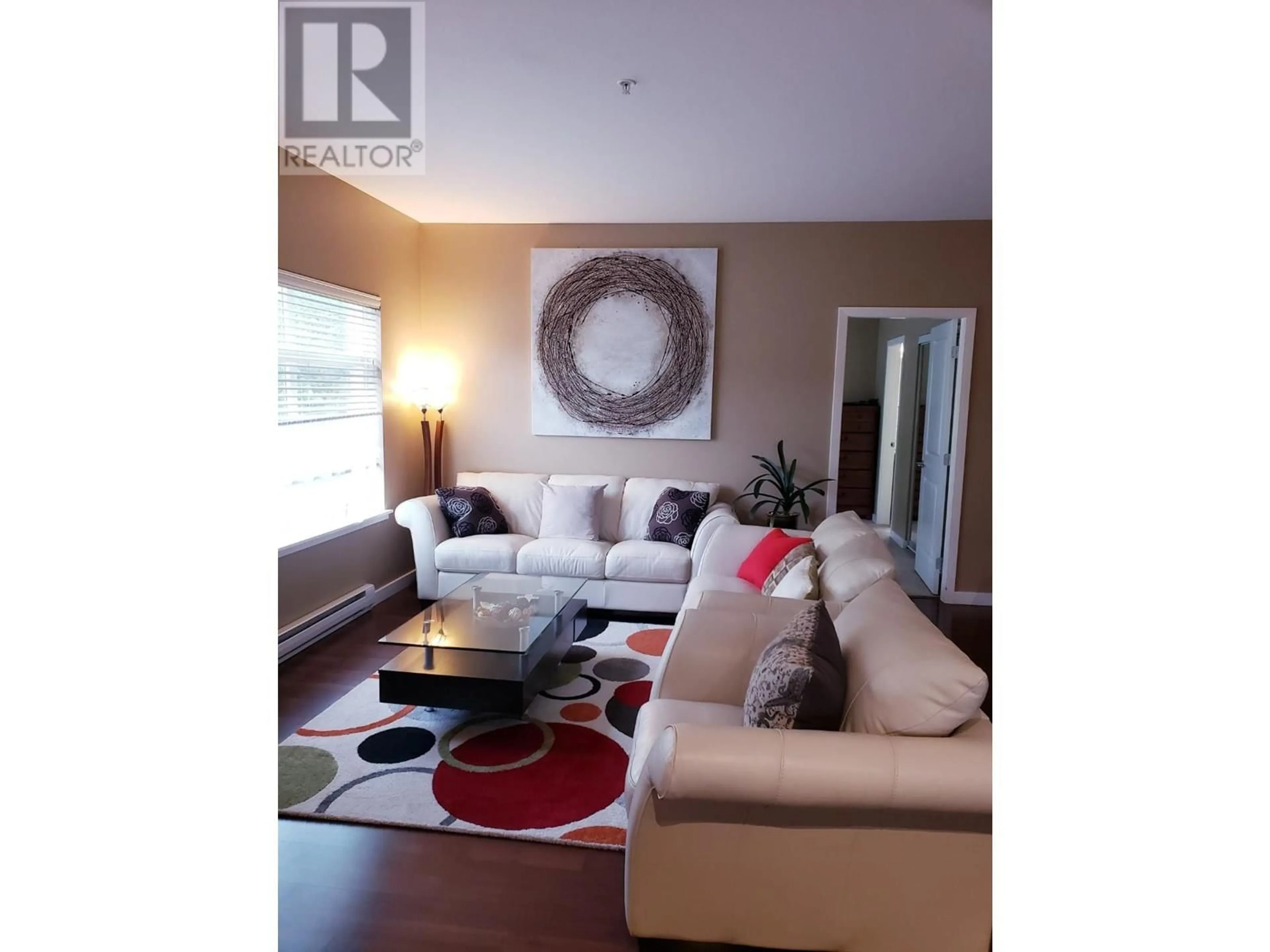 Living room with furniture, wood/laminate floor for 204 - 151 TAYLOR ROAD, Kelowna British Columbia V1X4G1