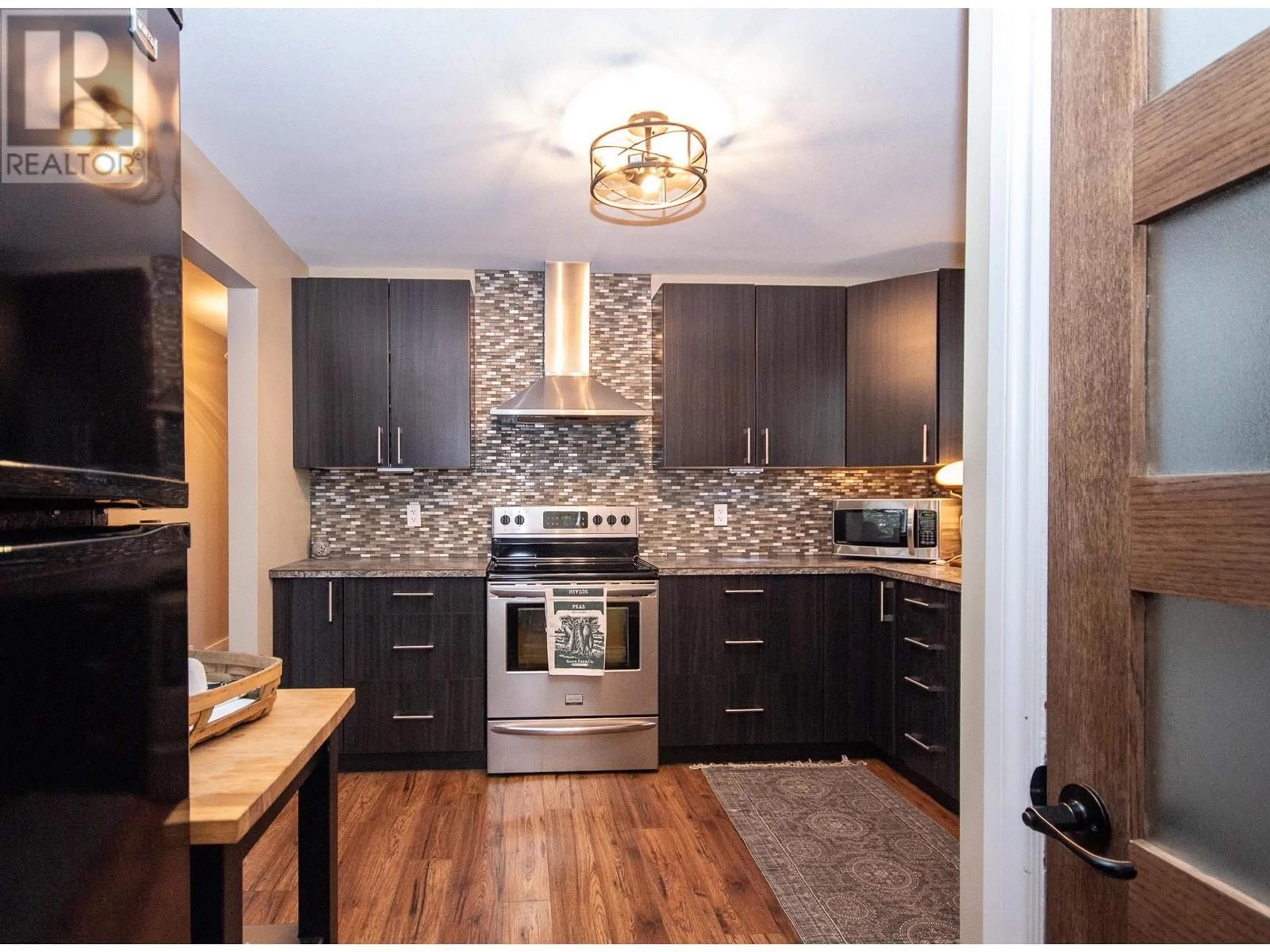 Open concept kitchen, wood/laminate floor for 1553 95 AVENUE, Dawson Creek British Columbia V1G1J9