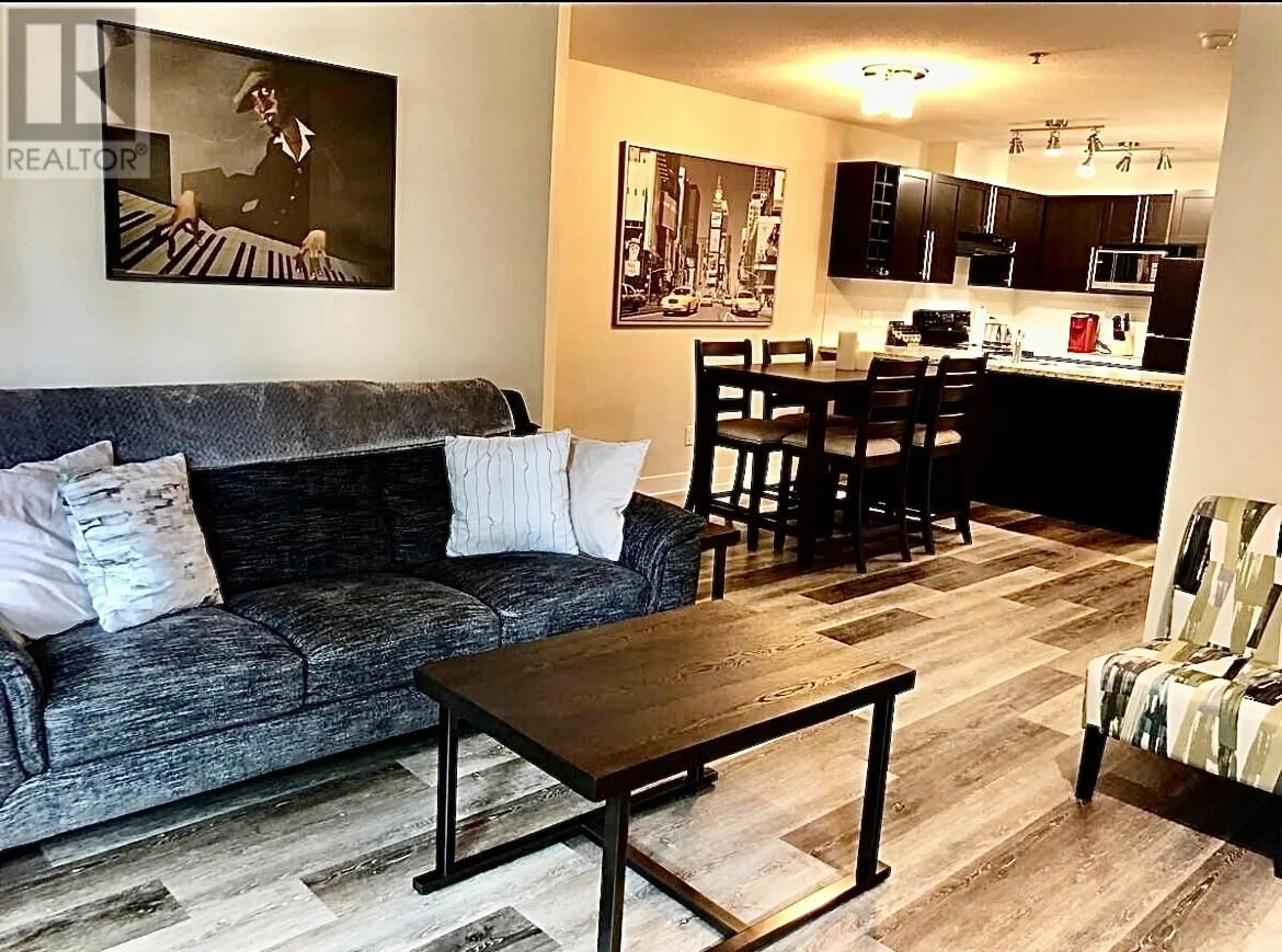 Living room with furniture, wood/laminate floor for 102 - 1089 SUNSET DRIVE, Kelowna British Columbia V1Y9Z3