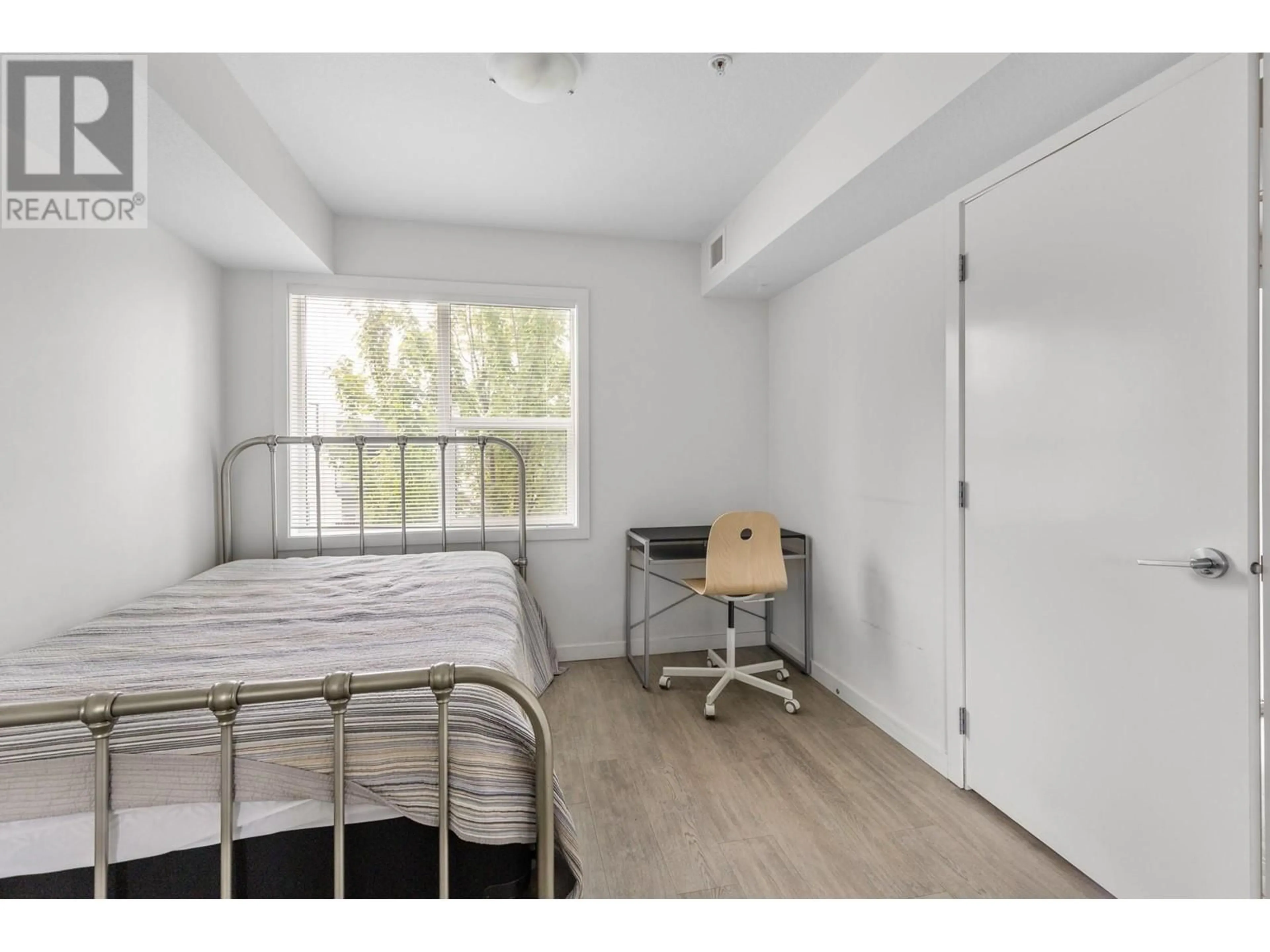 Bedroom with bed, wood/laminate floor for 105 - 695 ACADEMY WAY, Kelowna British Columbia V1V0C7
