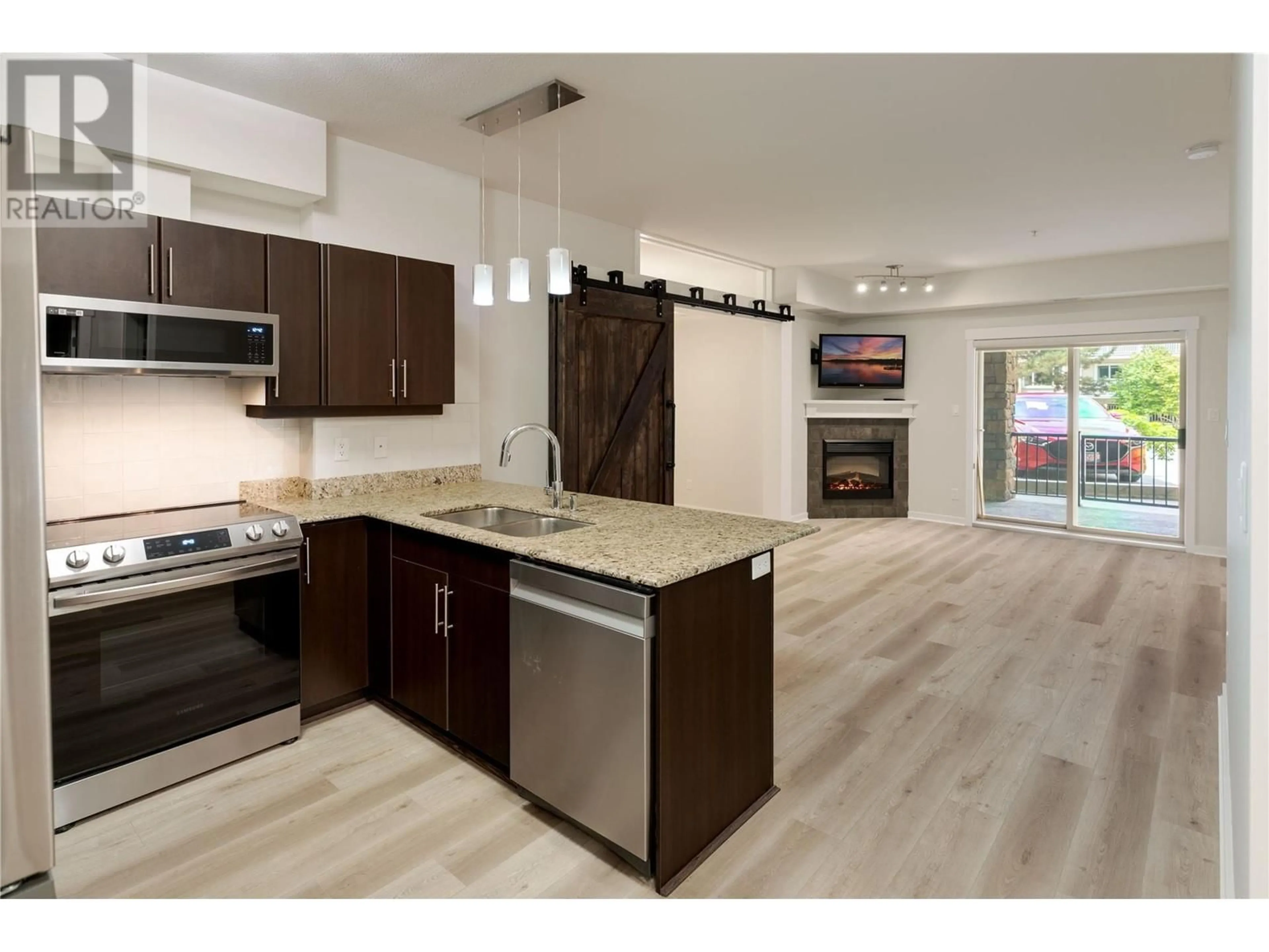Open concept kitchen, wood/laminate floor for 101 - 1957 KANE ROAD, Kelowna British Columbia V1V2X7