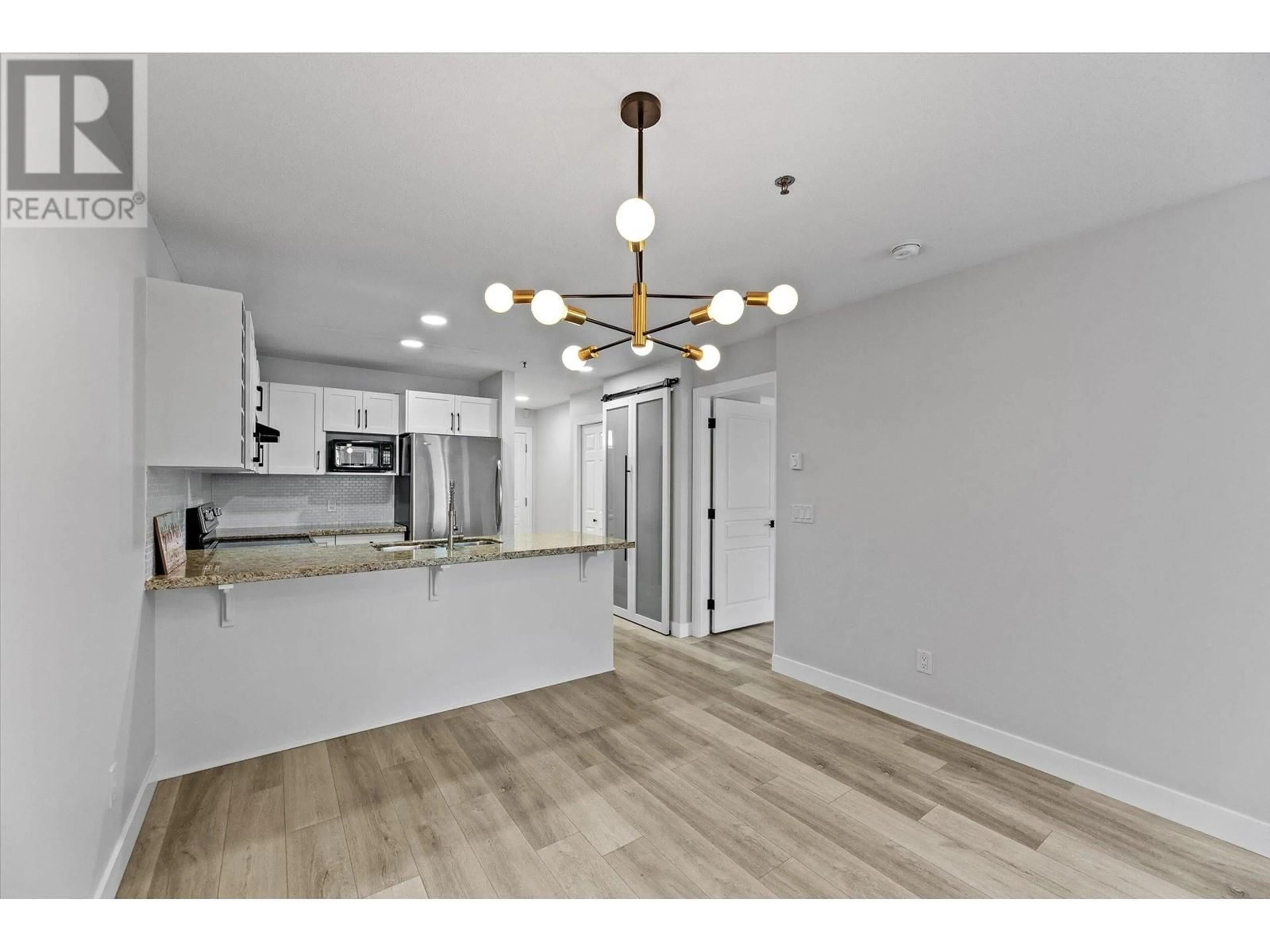 Open concept kitchen, wood/laminate floor for 319 - 1083 SUNSET DRIVE, Kelowna British Columbia V1Y9Z1