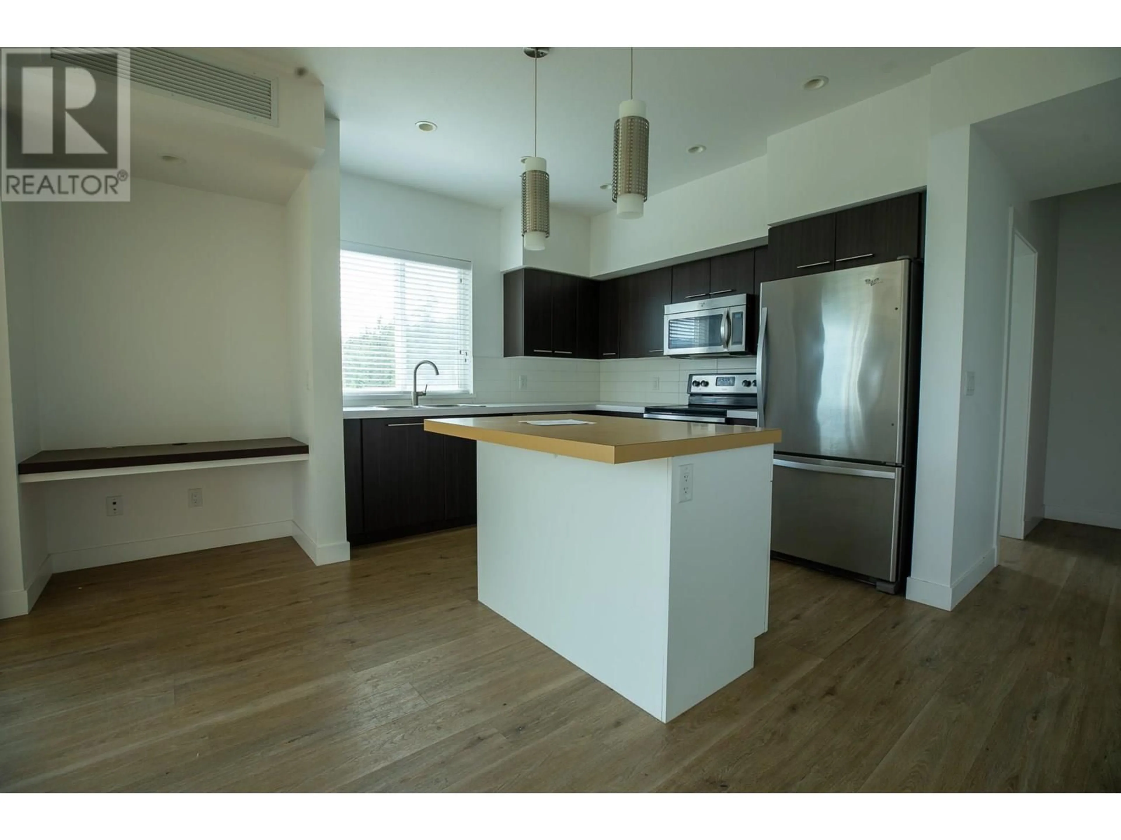 Open concept kitchen, wood/laminate floor for 307 - 985 ACADEMY WAY, Kelowna British Columbia V1V3C8