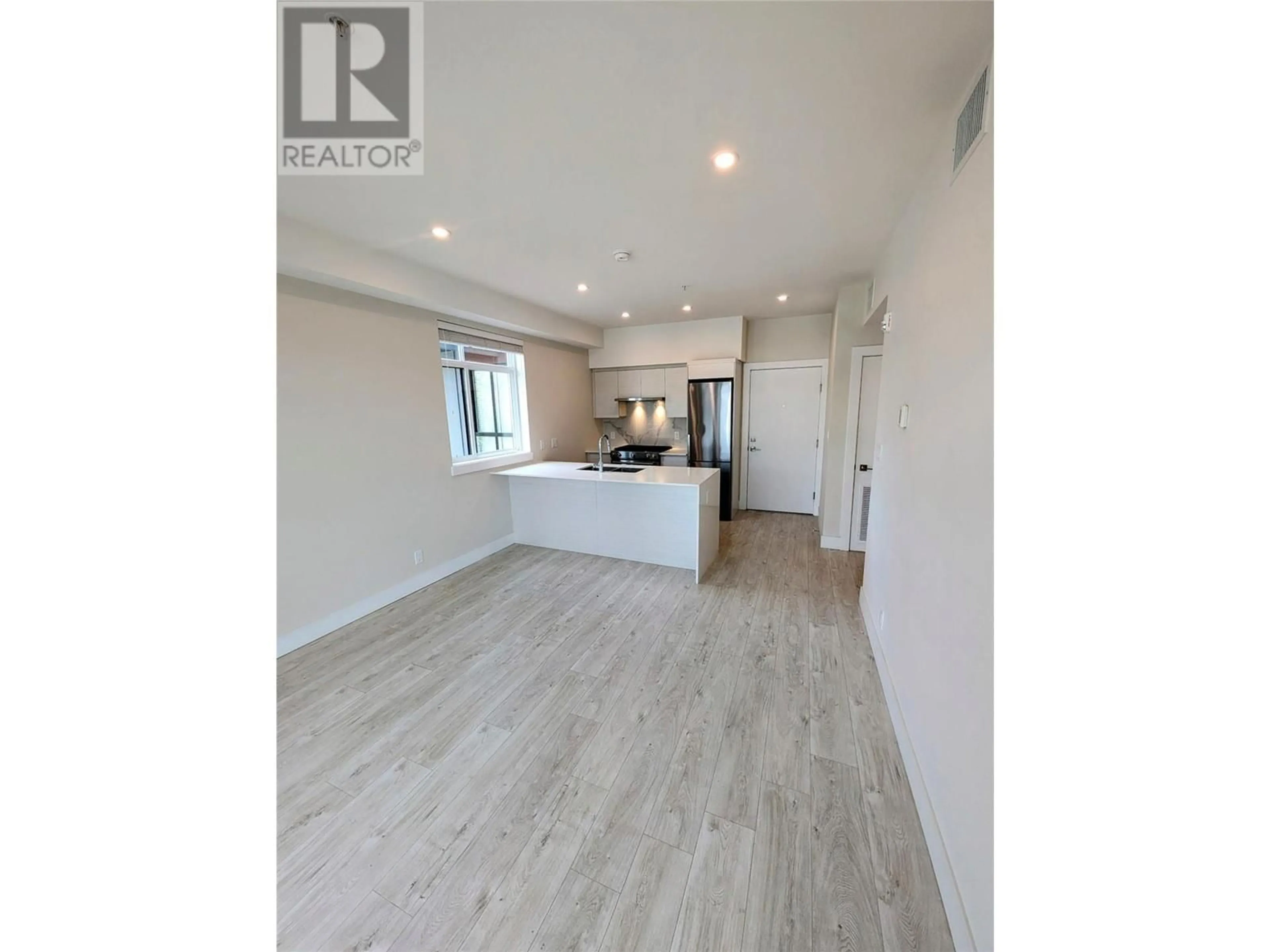 Open concept kitchen, wood/laminate floor for 403 - 1925 ENTERPRISE WAY, Kelowna British Columbia V1Y4P7