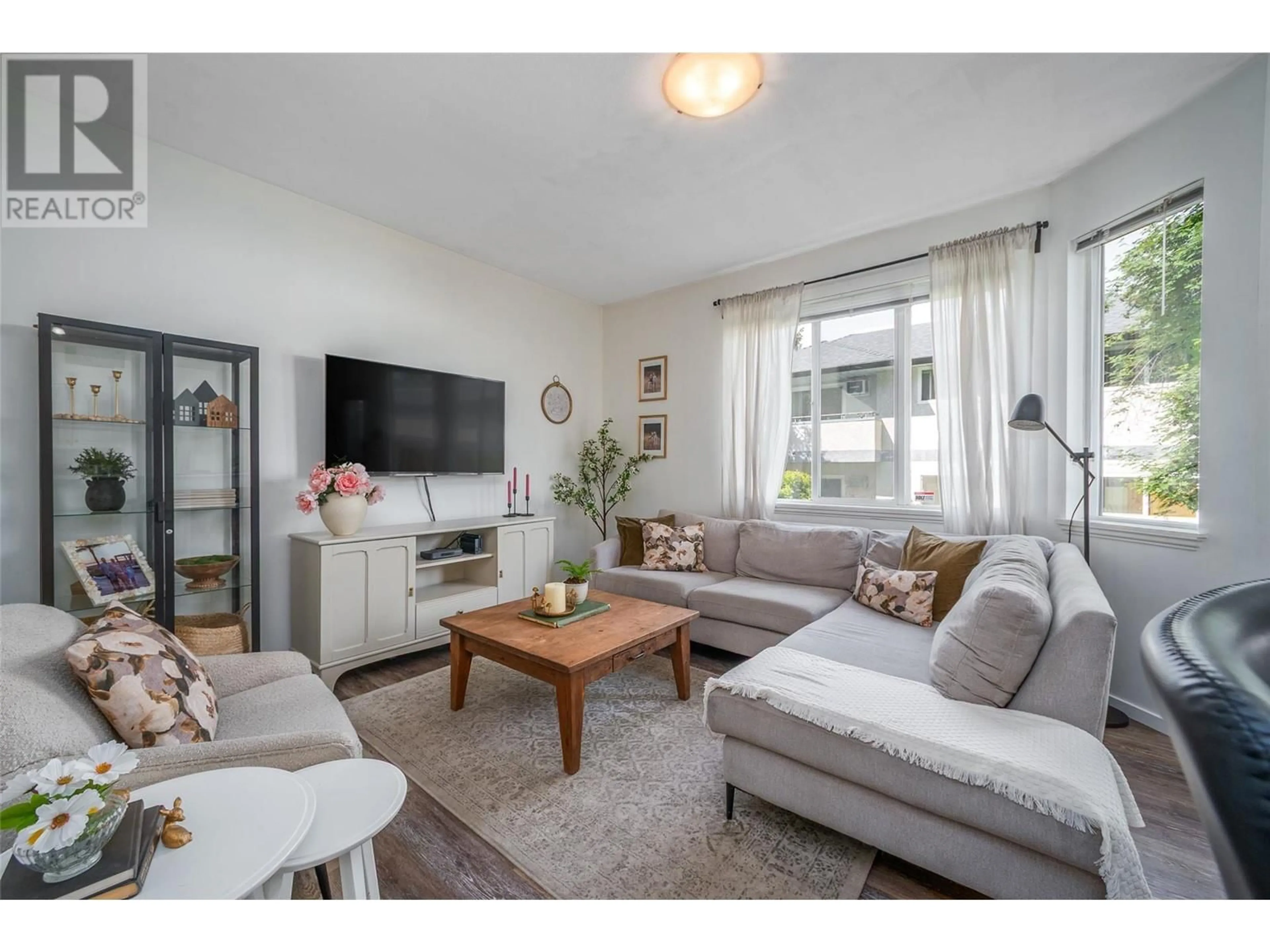 Living room with furniture, wood/laminate floor for 102 - 1420 TERAI ROAD, Kelowna British Columbia V1X7H3