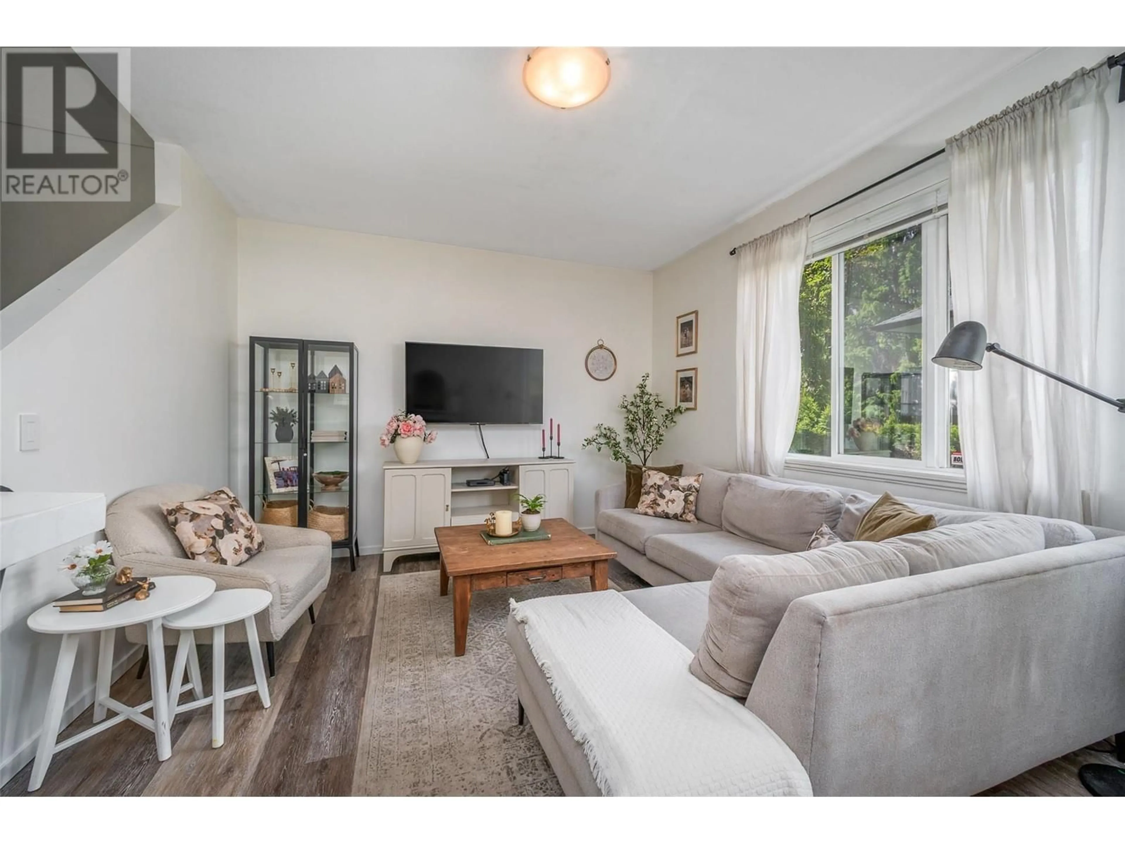 Living room with furniture, wood/laminate floor for 102 - 1420 TERAI ROAD, Kelowna British Columbia V1X7H3