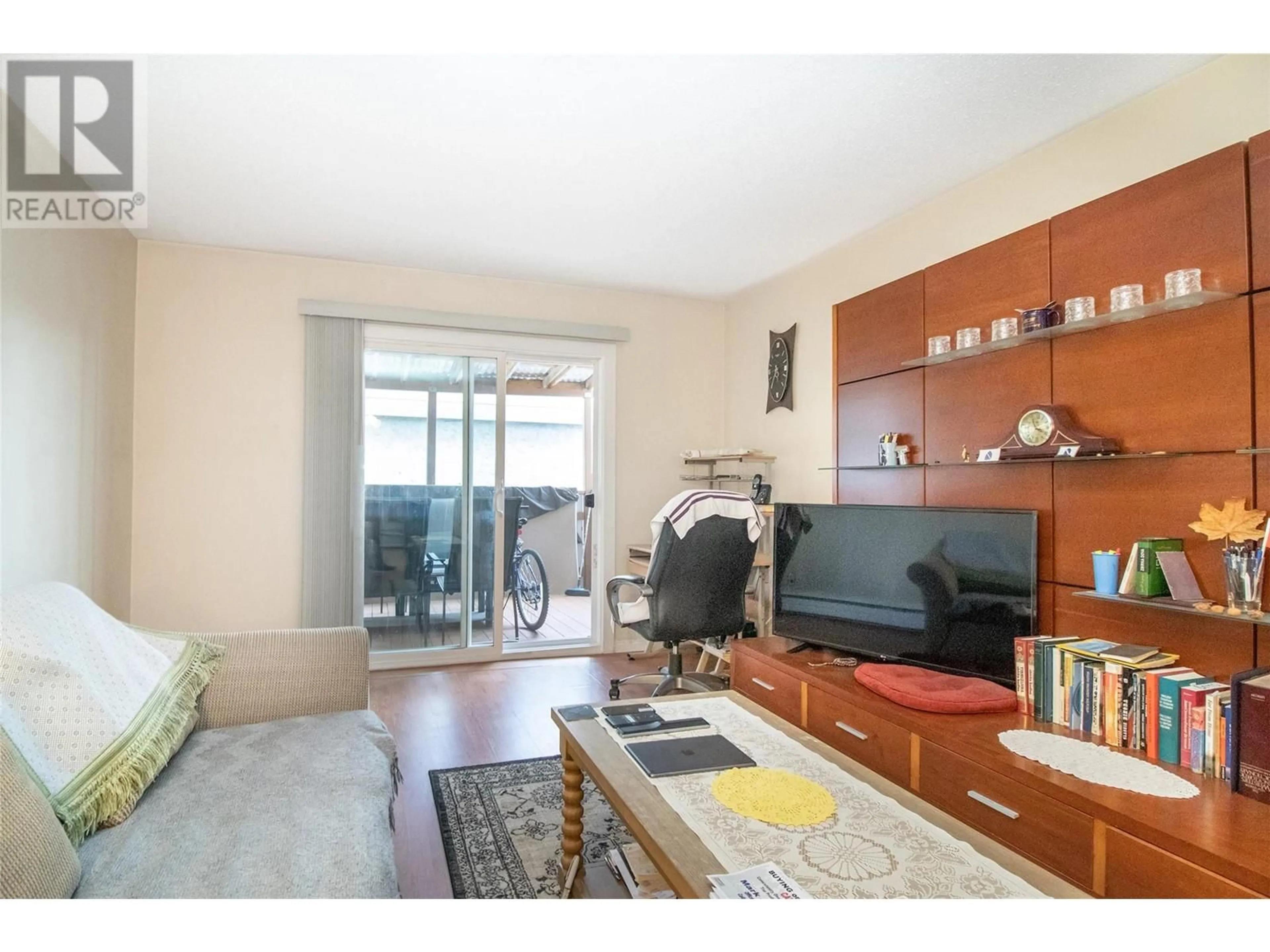 Living room with furniture, wood/laminate floor for 103 - 150 SCARBORO ROAD, Kelowna British Columbia V1X1M2