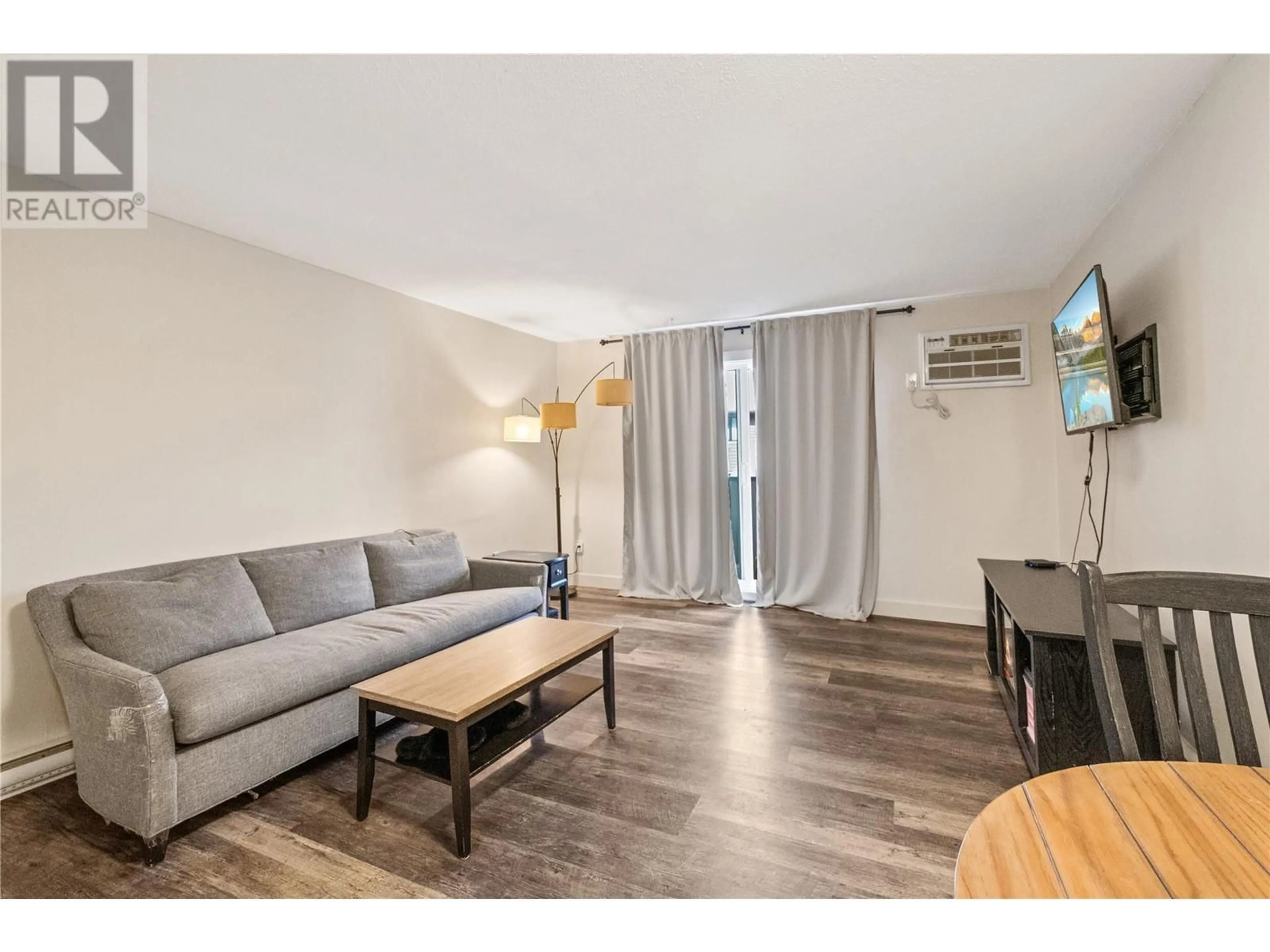 Living room with furniture, wood/laminate floor for 116 - 1640 UFTON COURT, Kelowna British Columbia V1Y8G7