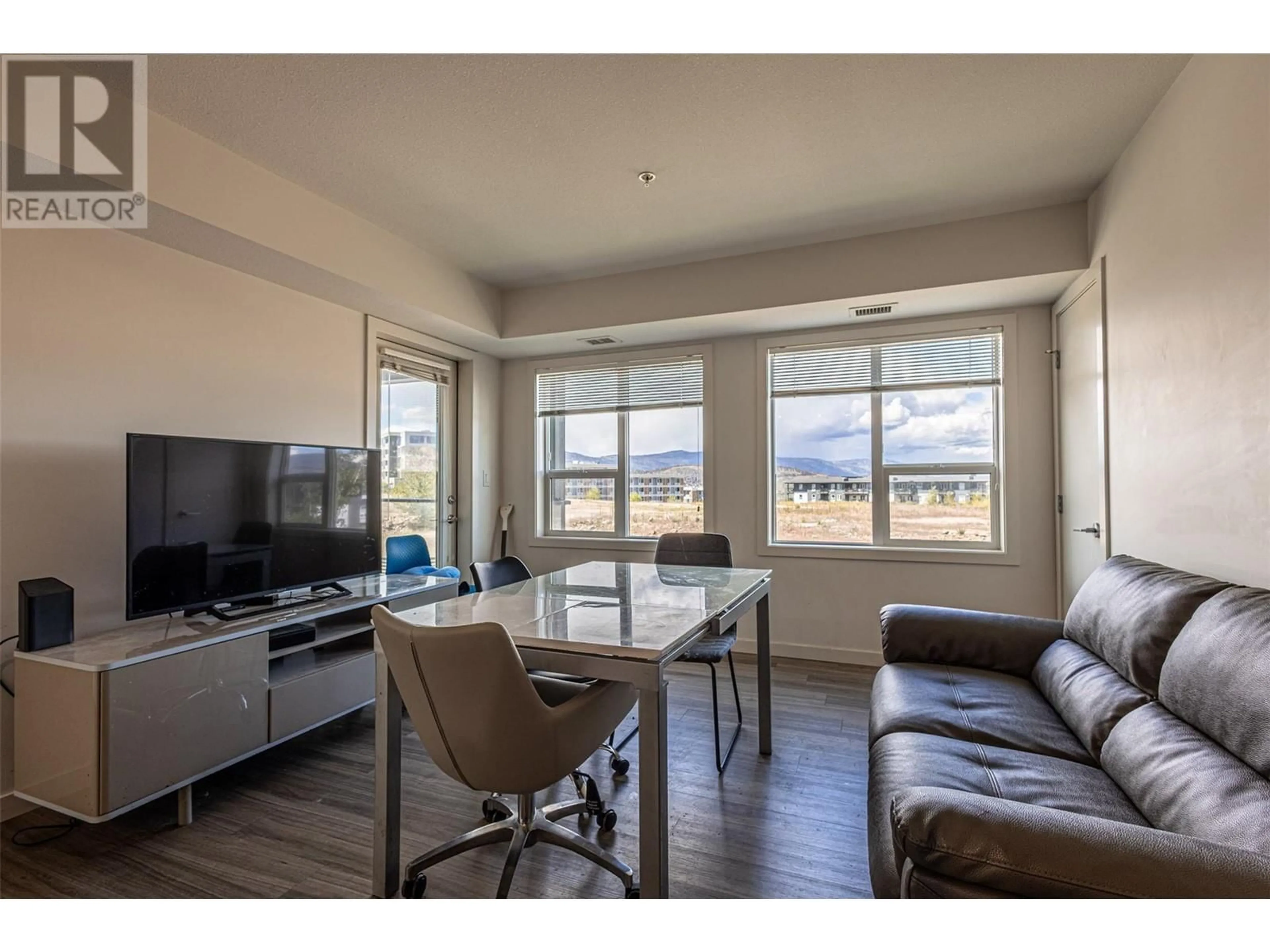 Living room with furniture, wood/laminate floor for 207 - 775 ACADEMY WAY, Kelowna British Columbia V7V0A5
