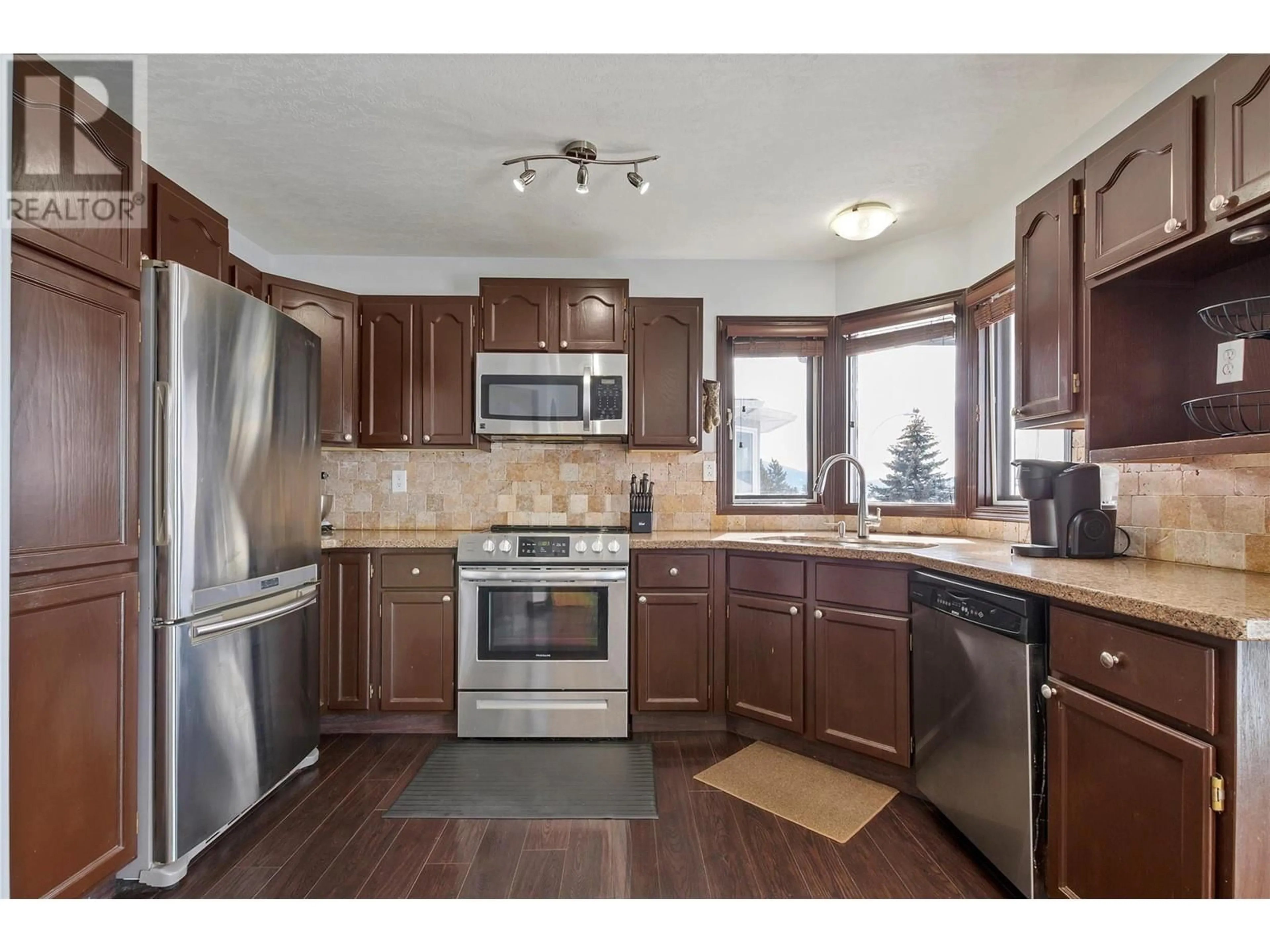 Open concept kitchen, wood/laminate floor for 4317 WELLINGTON DRIVE, Vernon British Columbia V1T9A6