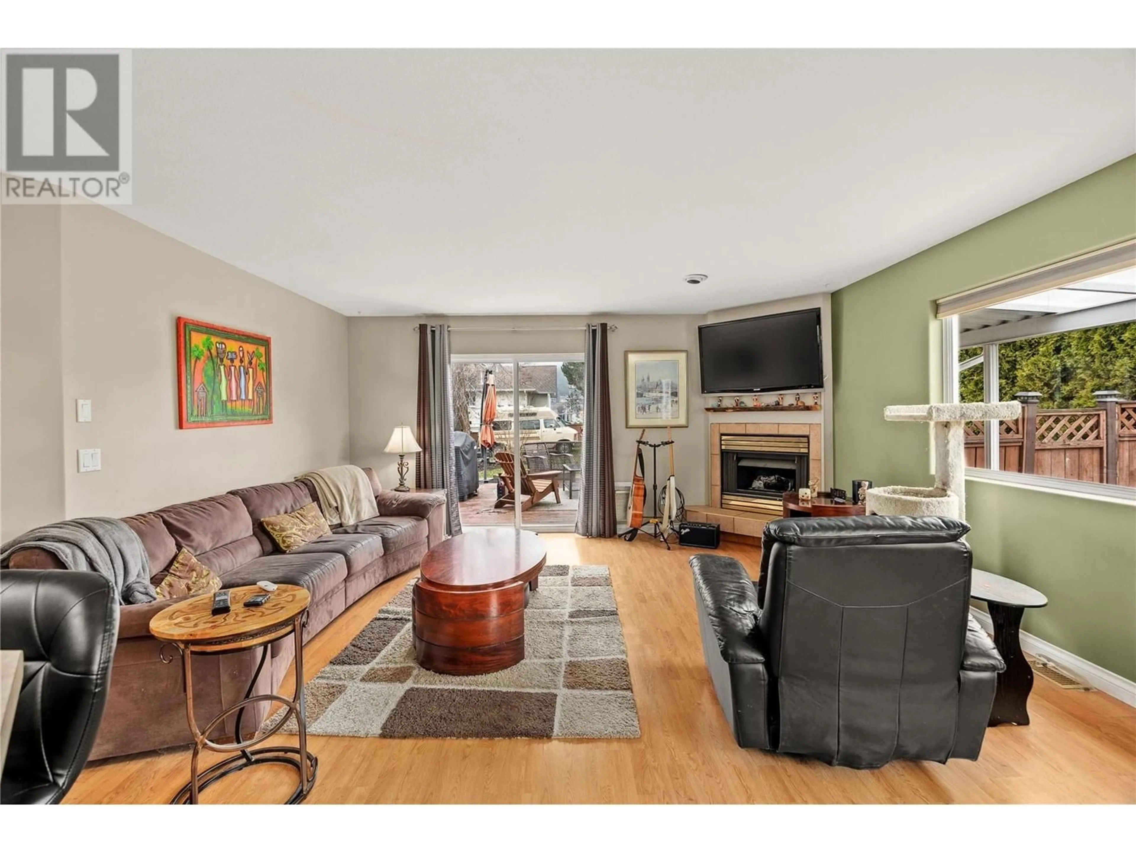 Living room with furniture, wood/laminate floor for 100 VERNA COURT, Kelowna British Columbia V4T2G3