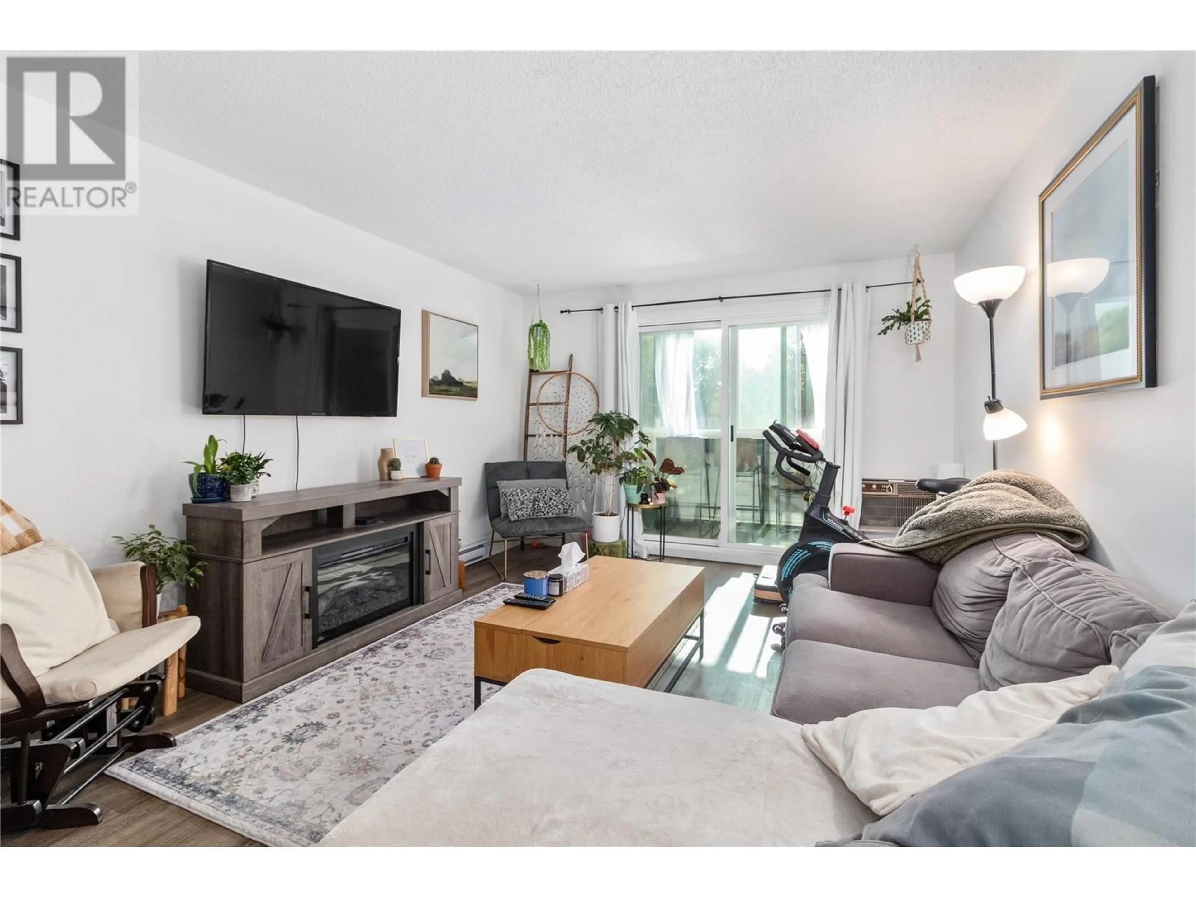 Living room with furniture, wood/laminate floor for 203 - 1915 PACIFIC COURT, Kelowna British Columbia V1Y8B3