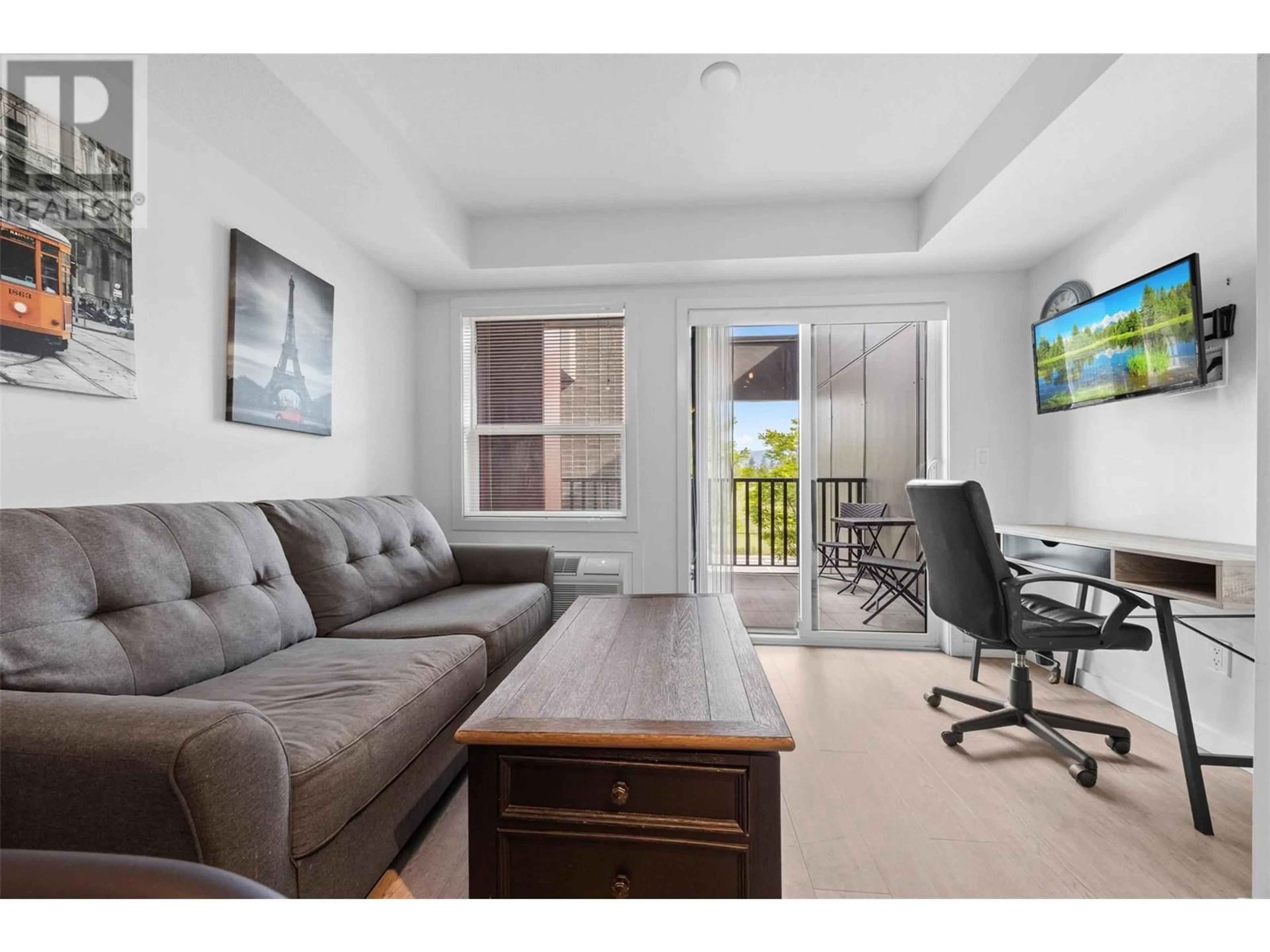Living room with furniture, wood/laminate floor for 103 - 625 ACADEMY WAY, Kelowna British Columbia V1V0E3