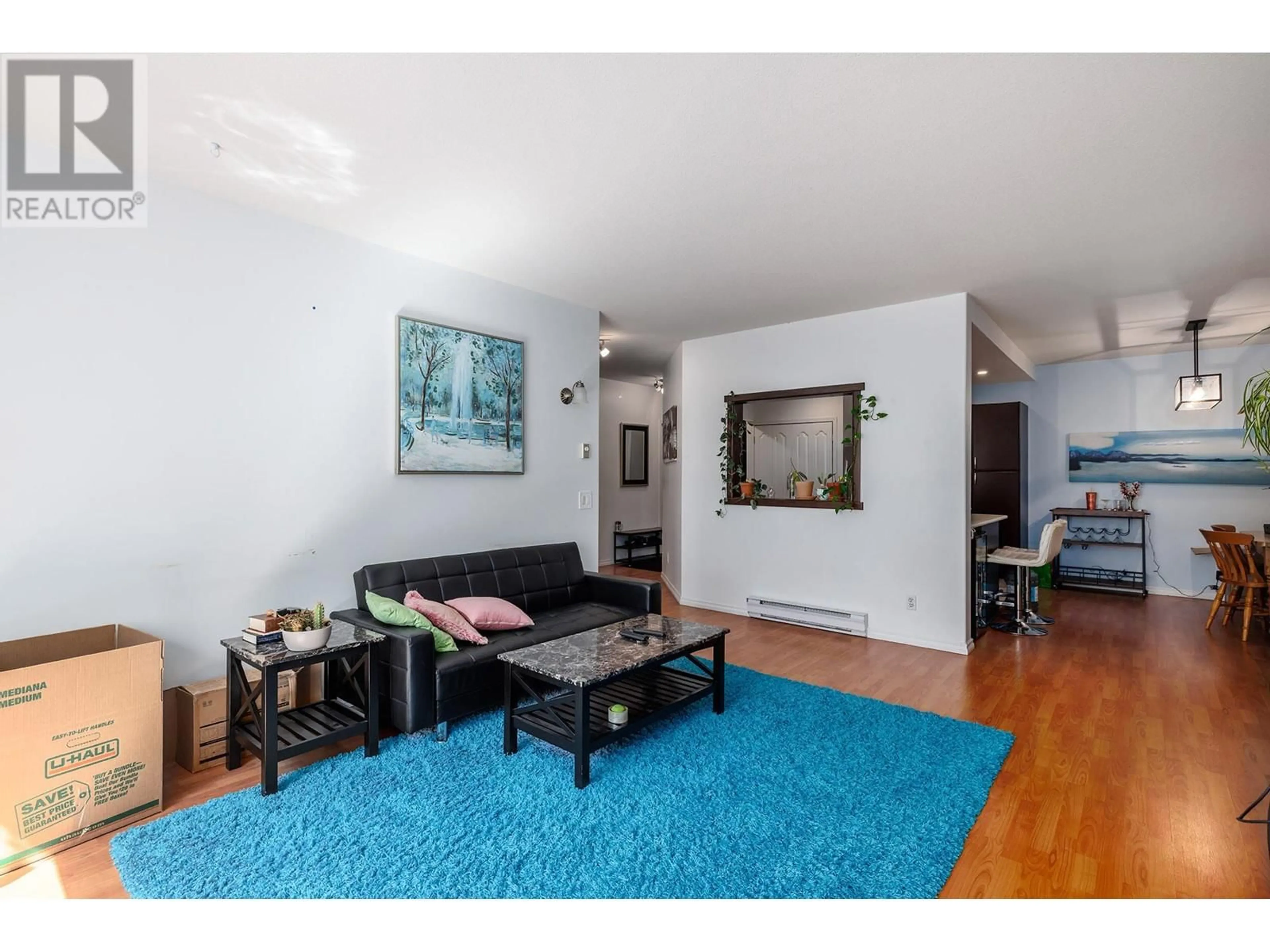 Living room with furniture, wood/laminate floor for 214 - 985 KLO ROAD, Kelowna British Columbia V1Y9L2